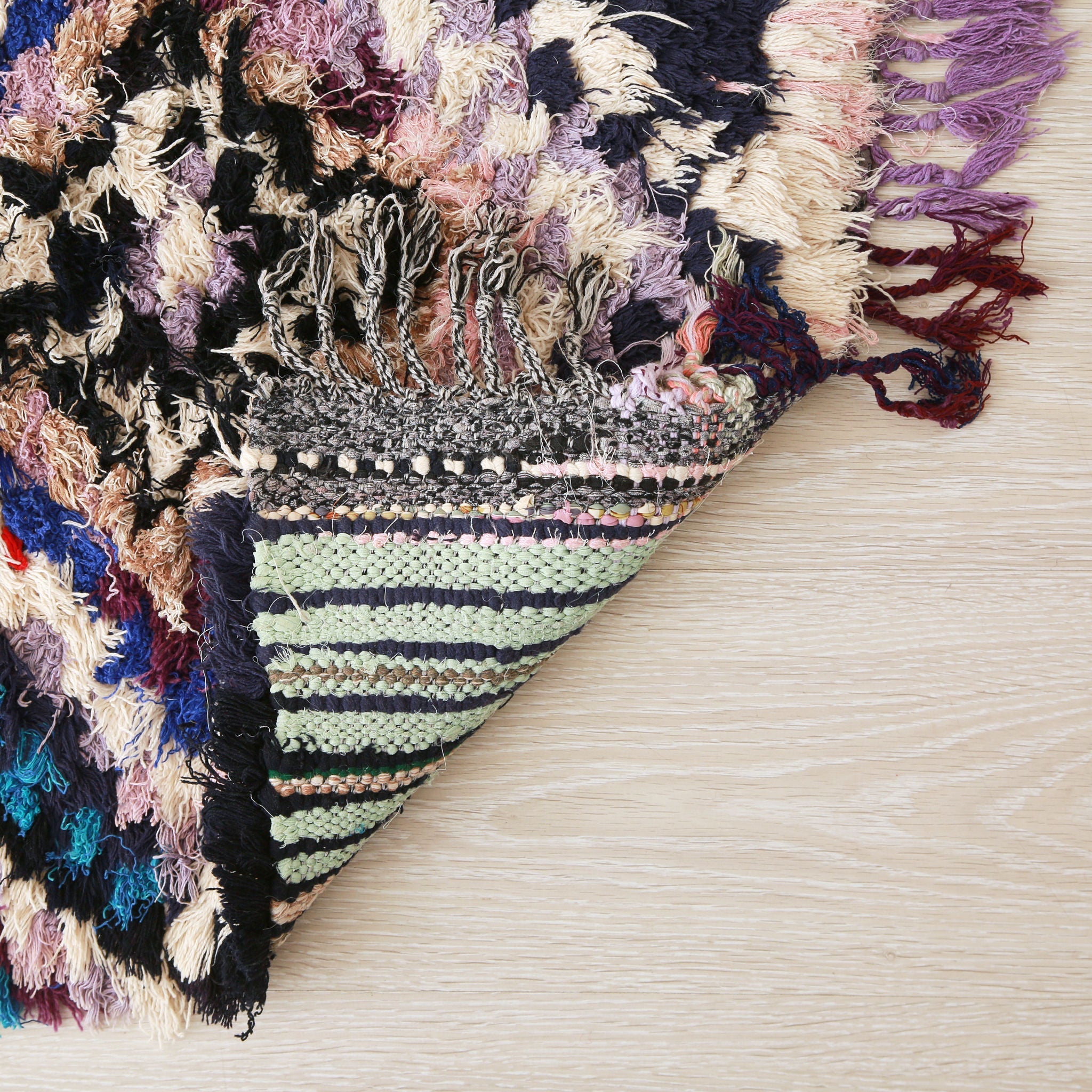 retro dell'angolo di un tappeto boucherouite vintage realizzato con fili di diverso colore