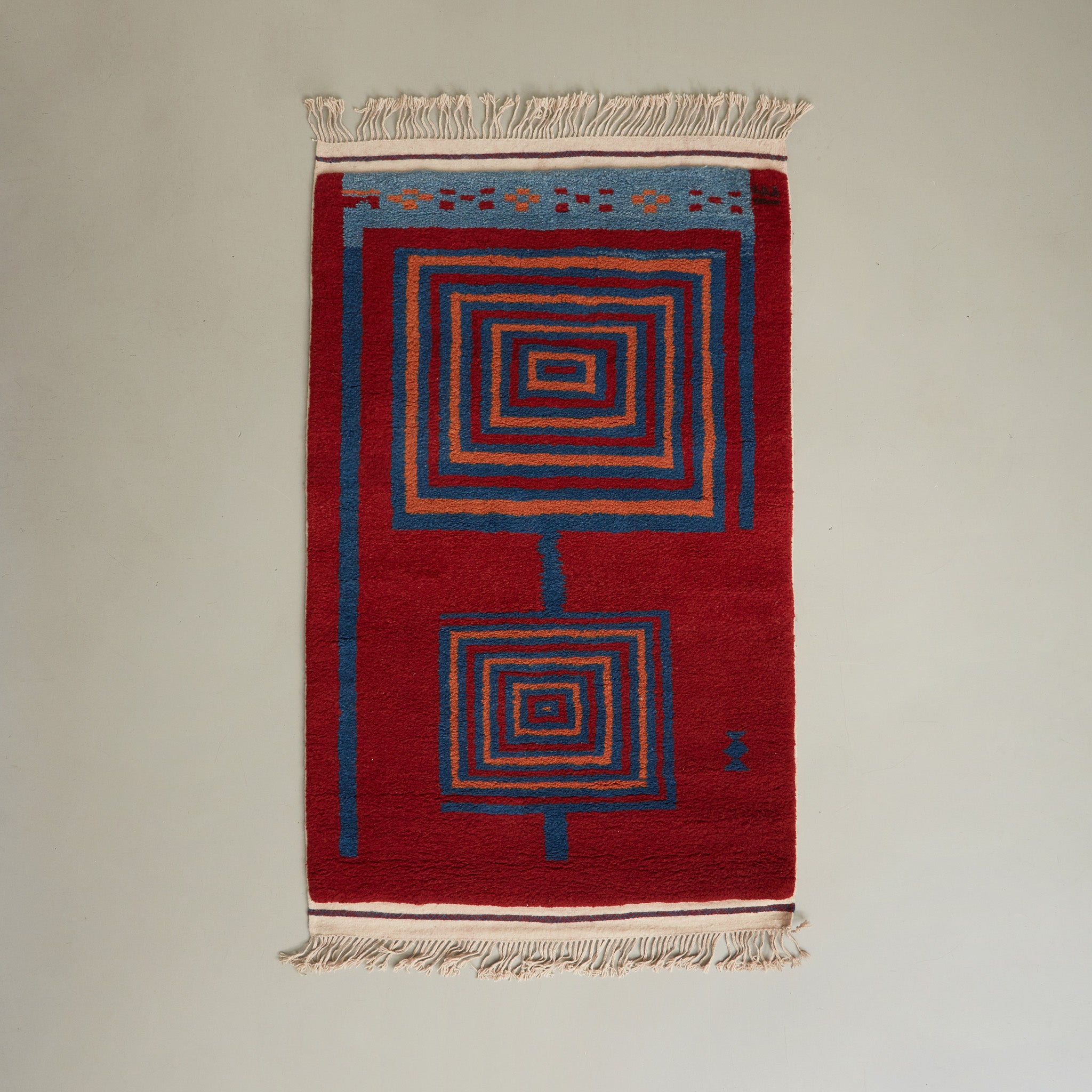 tappeto taznakht piccolo realizzato con lana siroua tinta con colori naturali su base rossa e disegni geometrici disteso su pavimento