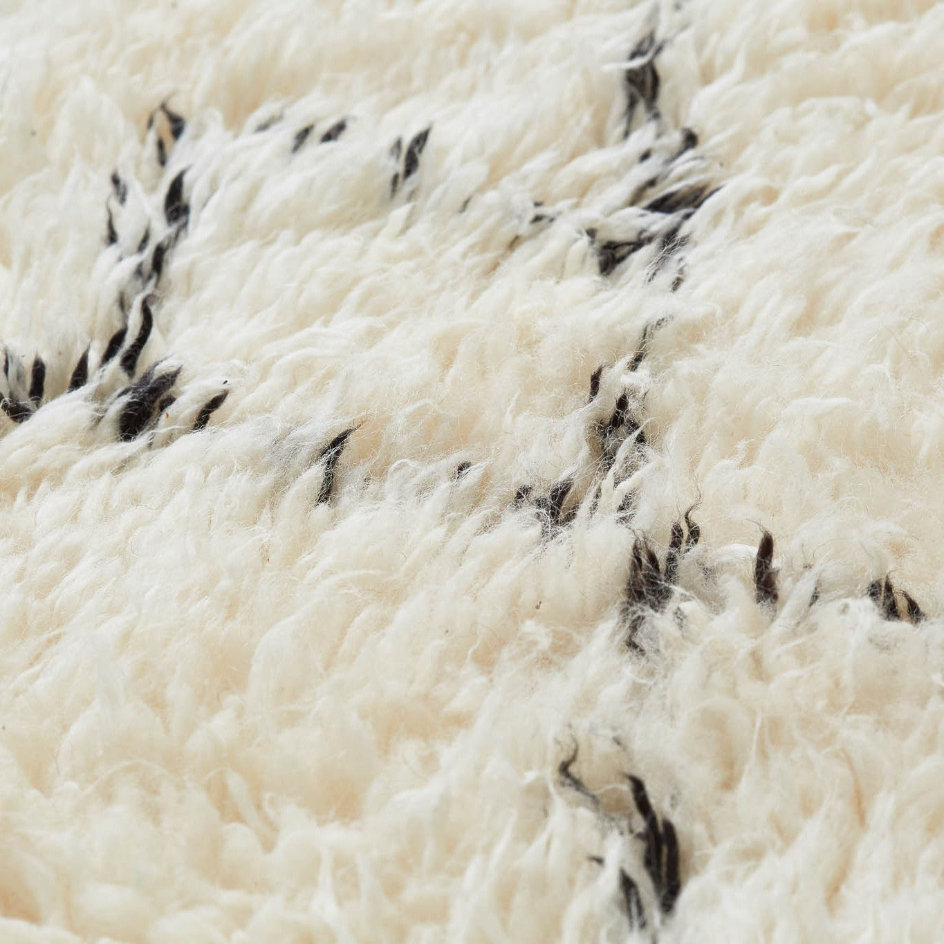 dettaglio di un tappeto beni ourain con pelo lungo e morbido di colore bianco e disegno geometrico di tipo romboidale