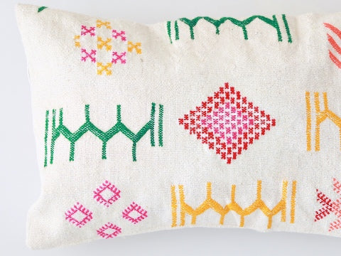 dettaglio di un cusciuno ricavato da un tappeto hanbel con ricami colorati di giallo rosa e verde che rappresentano dei simboli tradizionali della cultura amazigh