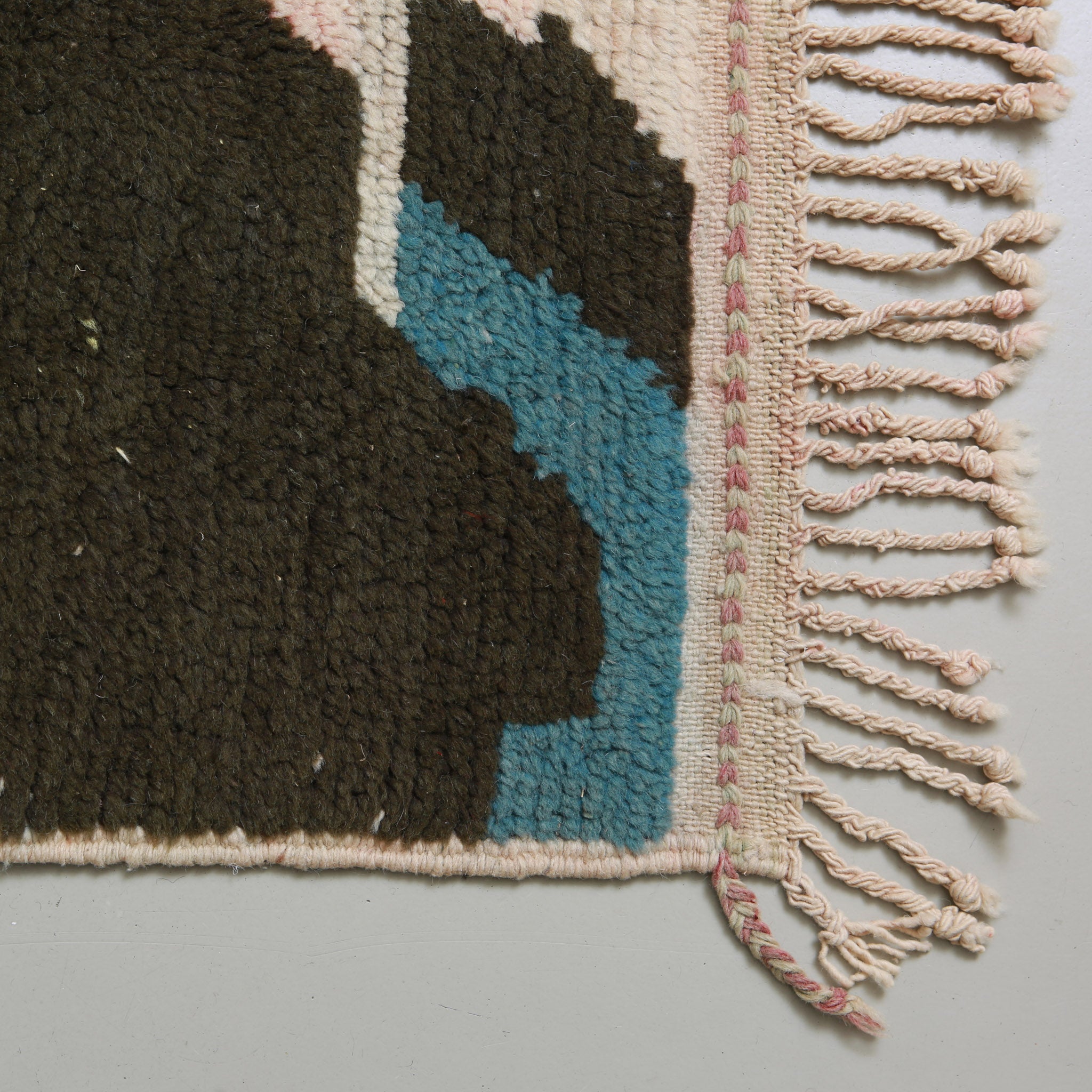 Close-up of handmade braided fringes on vintage Beni Mrirt rug showing traditional craftsmanship and pink detailing