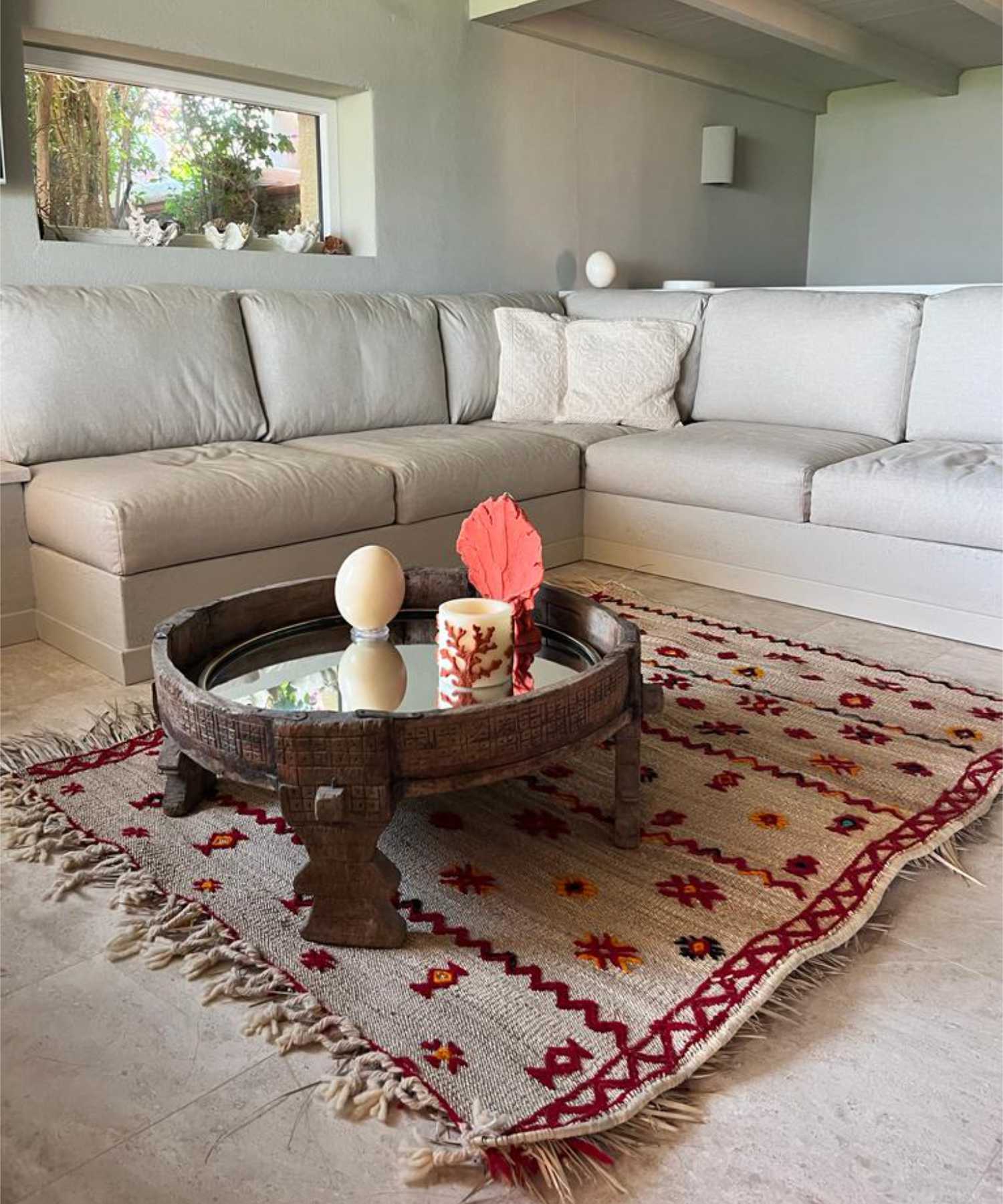 Palm straw Hassira mat with red and orange wool embroidery perfect for this Mediterranean, contemporary, coastal and modern ethnic living room, with light corner sofa and Moroccan coffee table