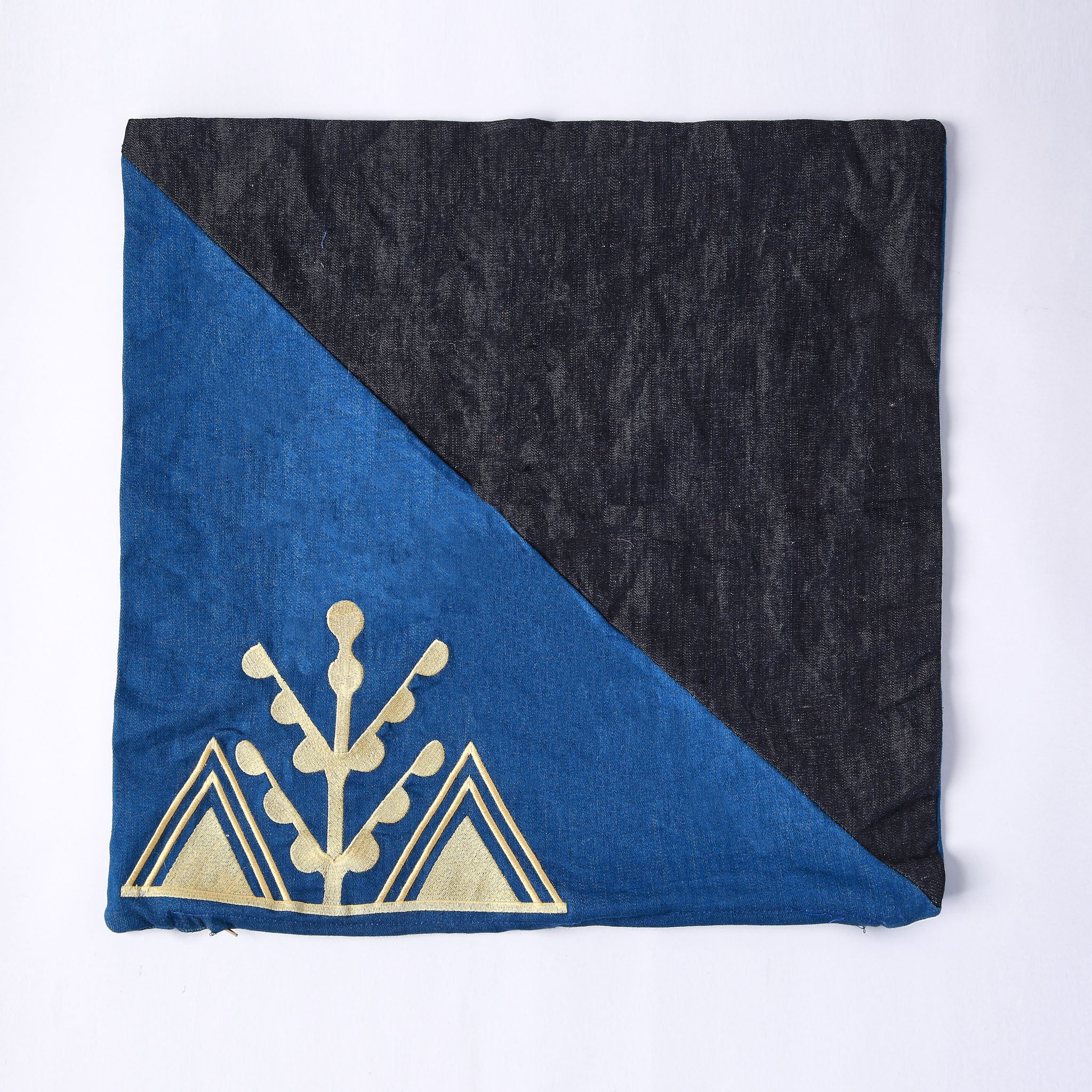 cuscino quadrato realizzato con tessuti in jeans di due colori e ricamo giallo del simbolo amazigh dell'ulivo