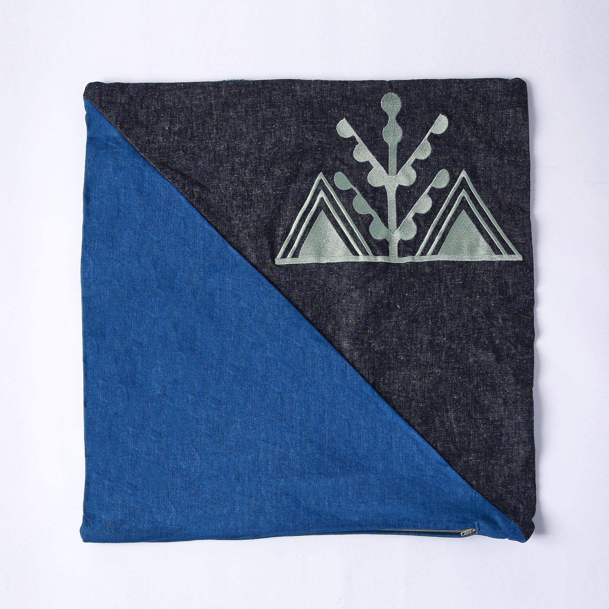 cuscino quadrato realizzato con tessuti in jeans di due colori e ricamo verde chiaro del simbolo amazigh dell'ulivo