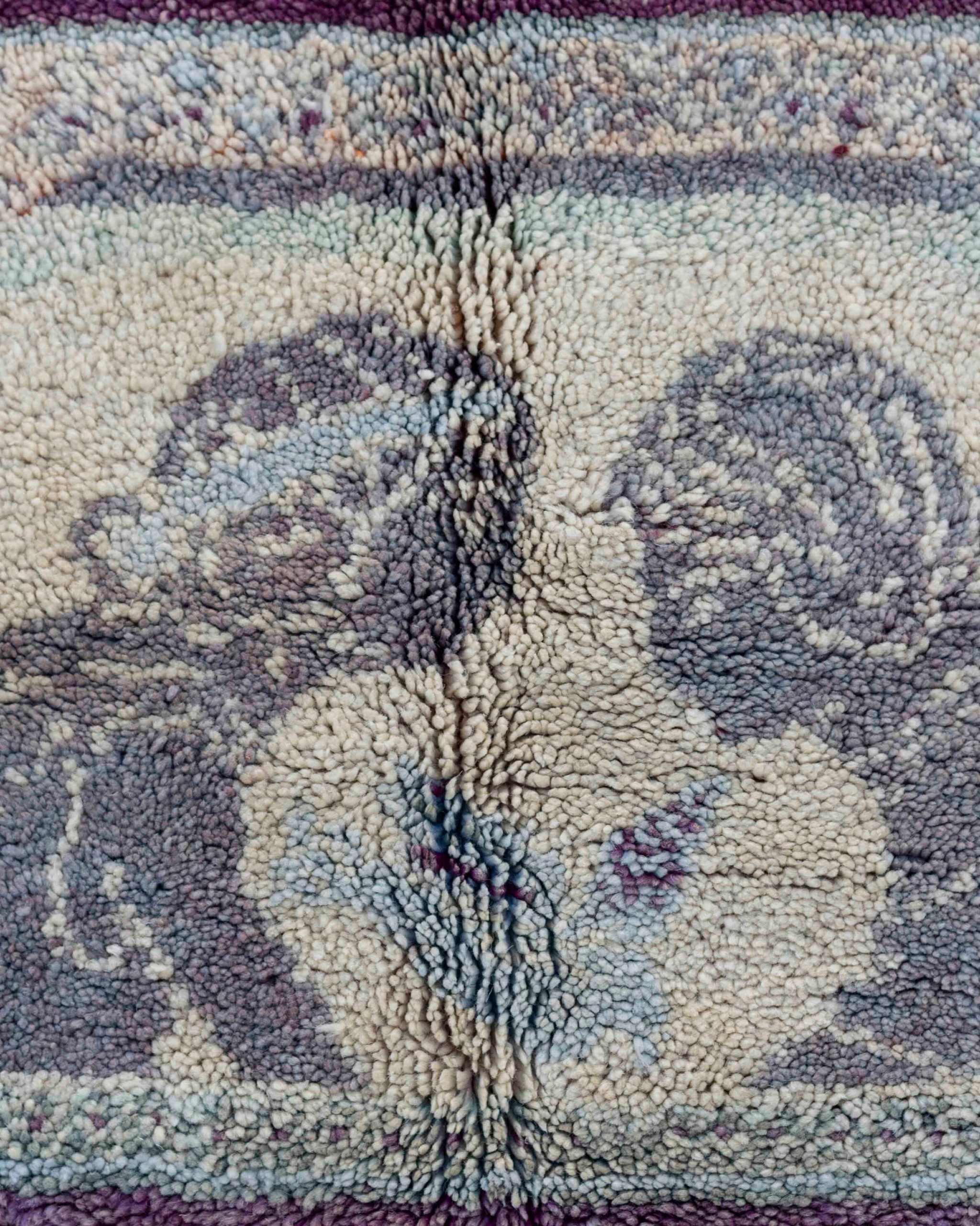 Dettaglio del medaglione a cammeo tessile centrale del tappeto Boujaad vintage con due figure umane e un uccello azzurro