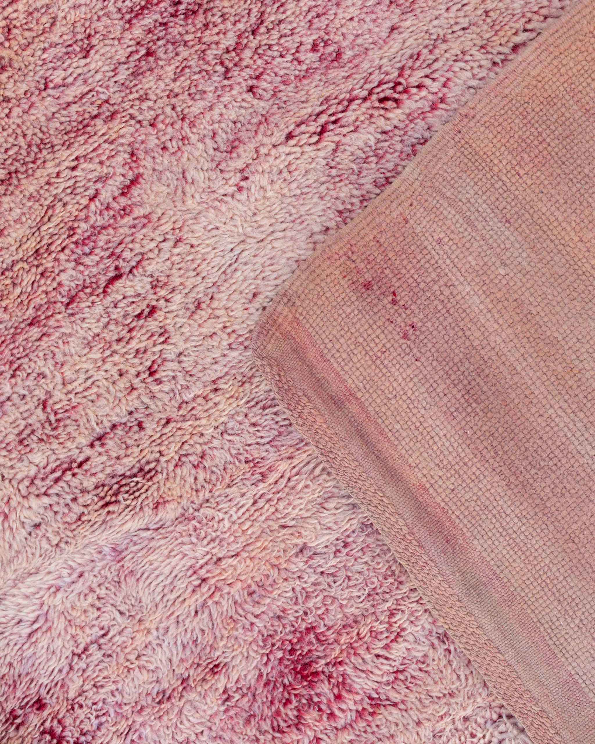 Dettaglio del tappeto rosa mélange pesca, cipria e lampone con vello medio-lungo morbido, retro a nodi fitti