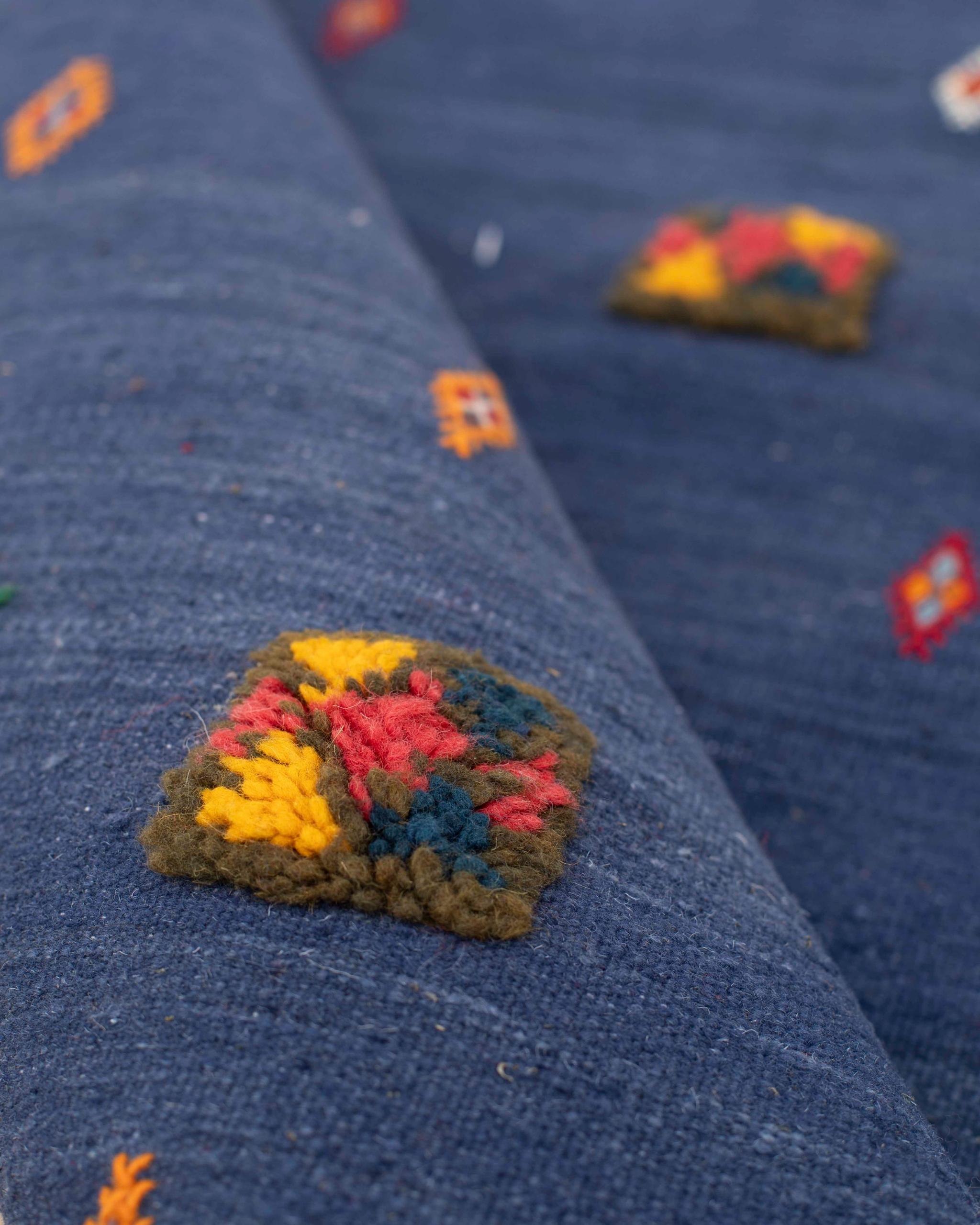 Dettaglio di un piccolo motivo in rilievo sul fondo blu indaco del kilim marocchino