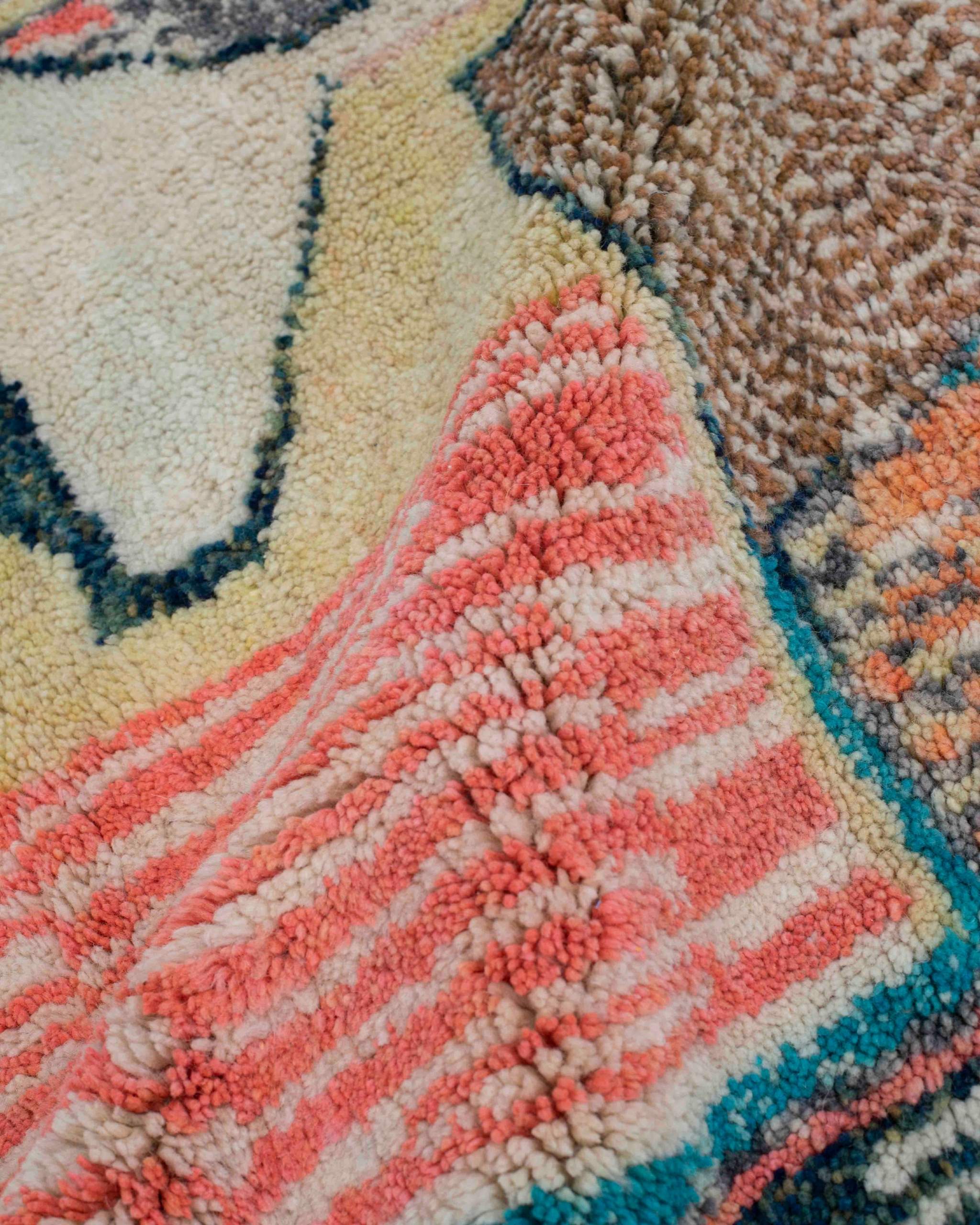 Texture ravvicinata del tappeto astratto a righe corallo e delle campiture marroni, gialle, azzurre e blu