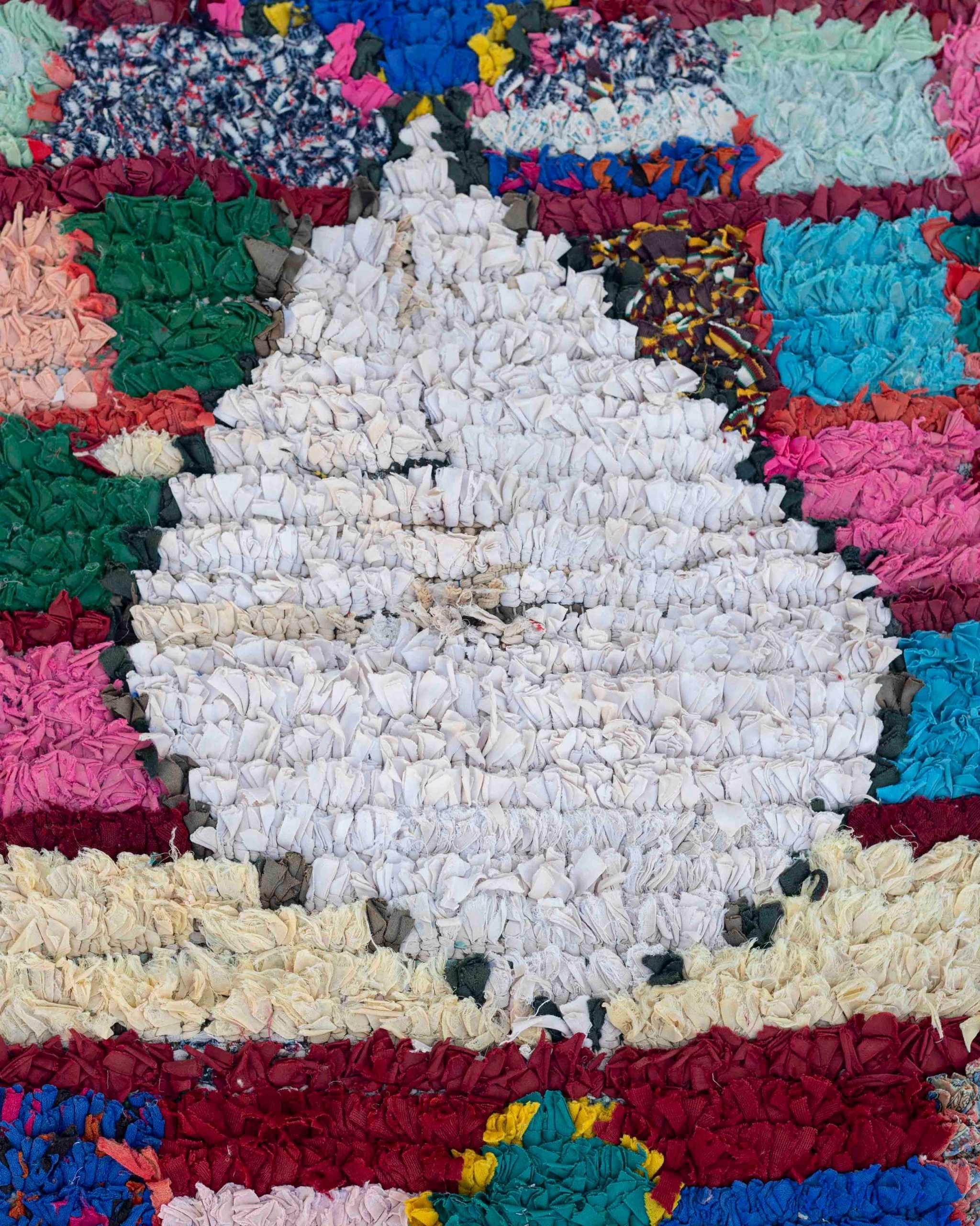Dettaglio del grande rombo centrale bianco del tappeto Boucherouite vintage in tessuti riciclati multicolore