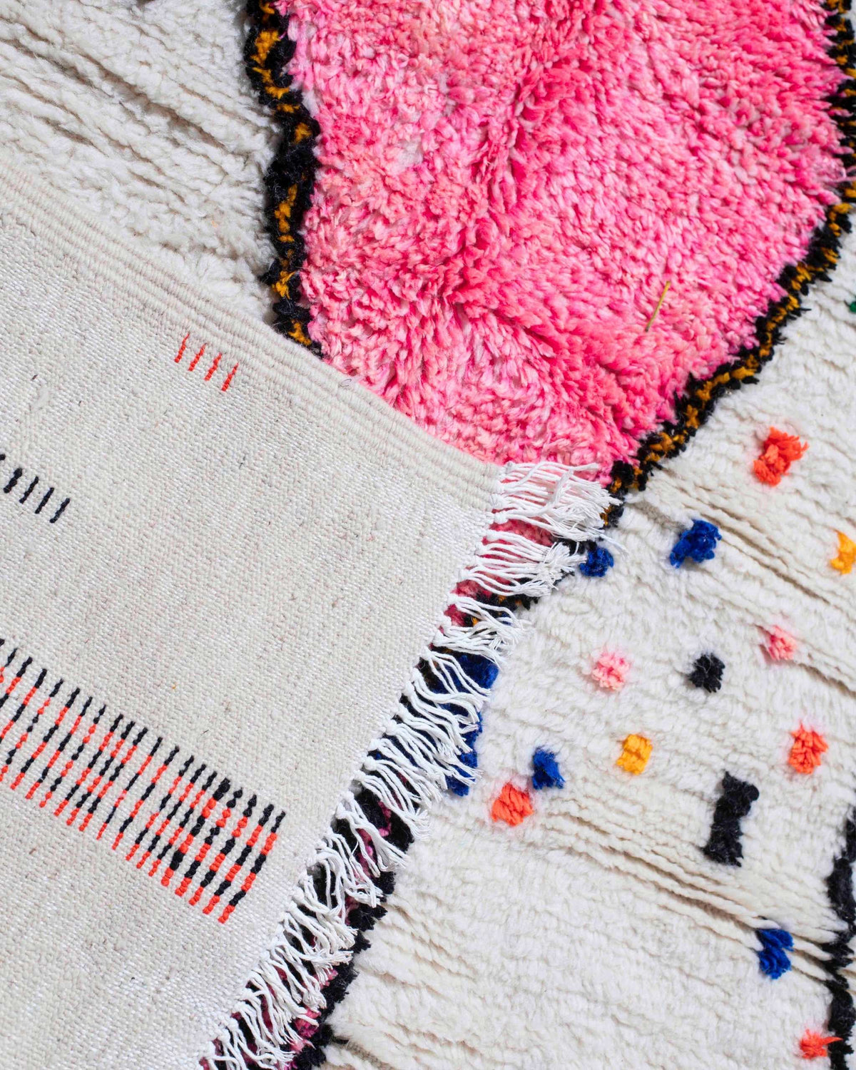 Dettaglio del rovescio e delle frange bianche del tappeto Azilal con grande rombo rosa e pois multicolor