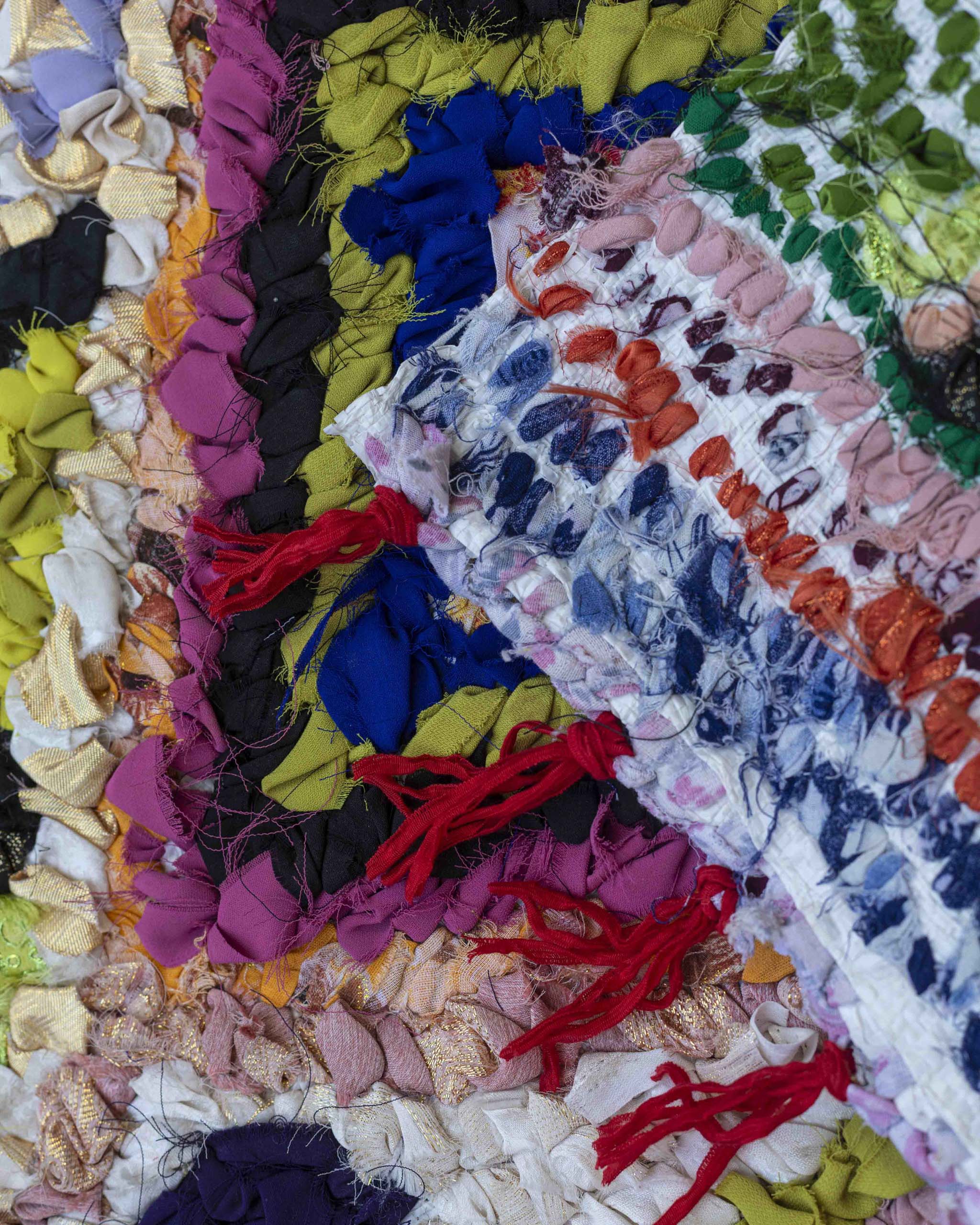 Dettaglio del dritto e del rovescio con base in plastica e tessuti annodati colorati a vista