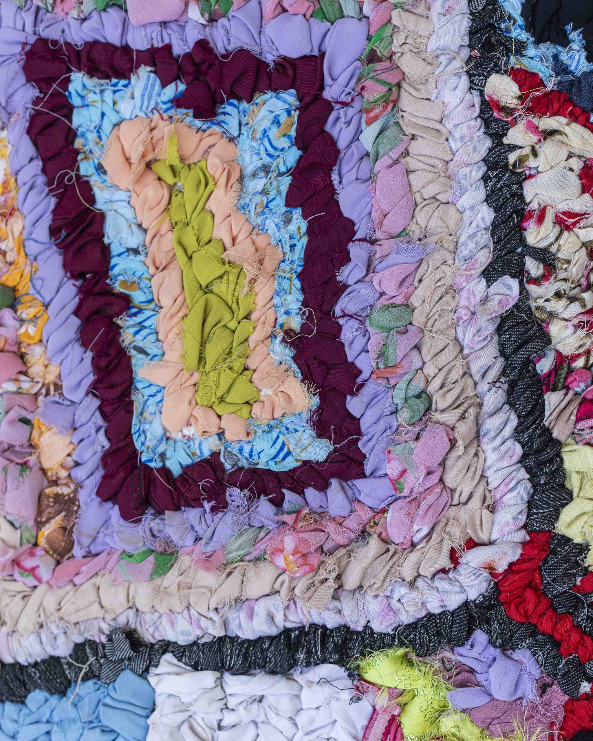 Dettaglio del tappetino fatto di strisce di stoffa riciclata di vari colori annodate a mano