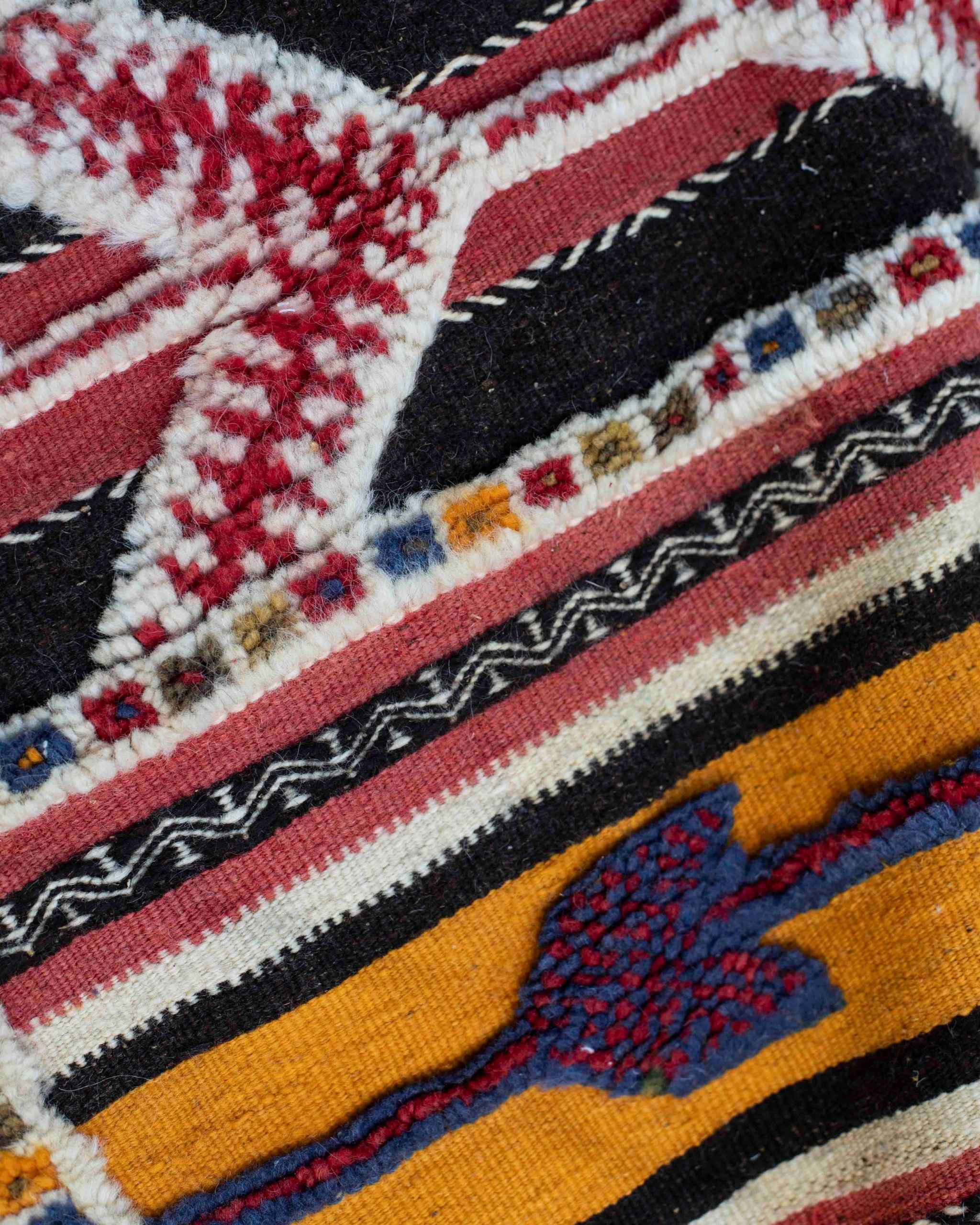 Dettaglio della trama mista del tappeto etnico Glaoui con fasce a tessitura piatta e fasce a pelo corto in colori vivaci primari