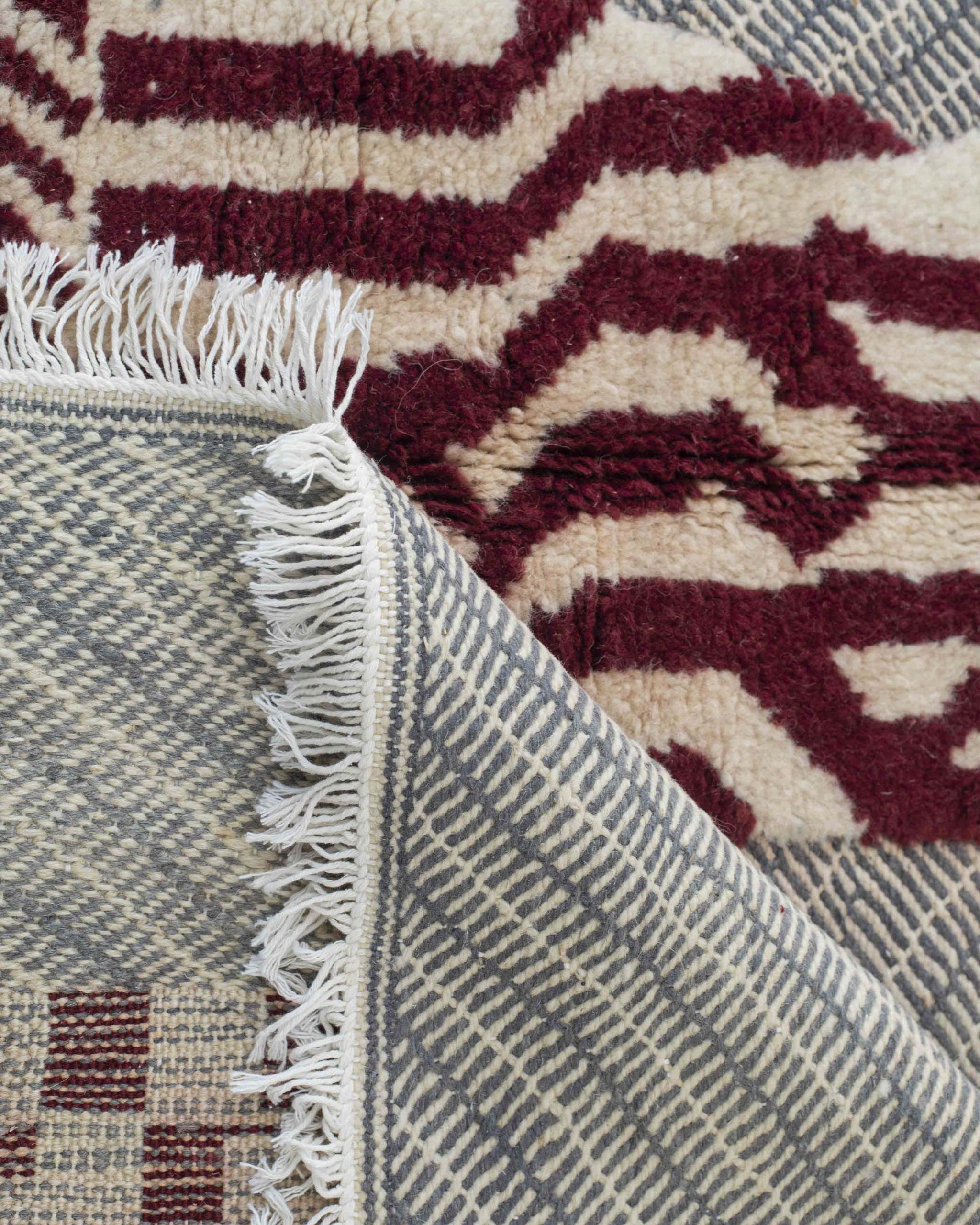 Dettaglio fronte e rovescio del tappeto grigio-rosso in lana fatto a mano