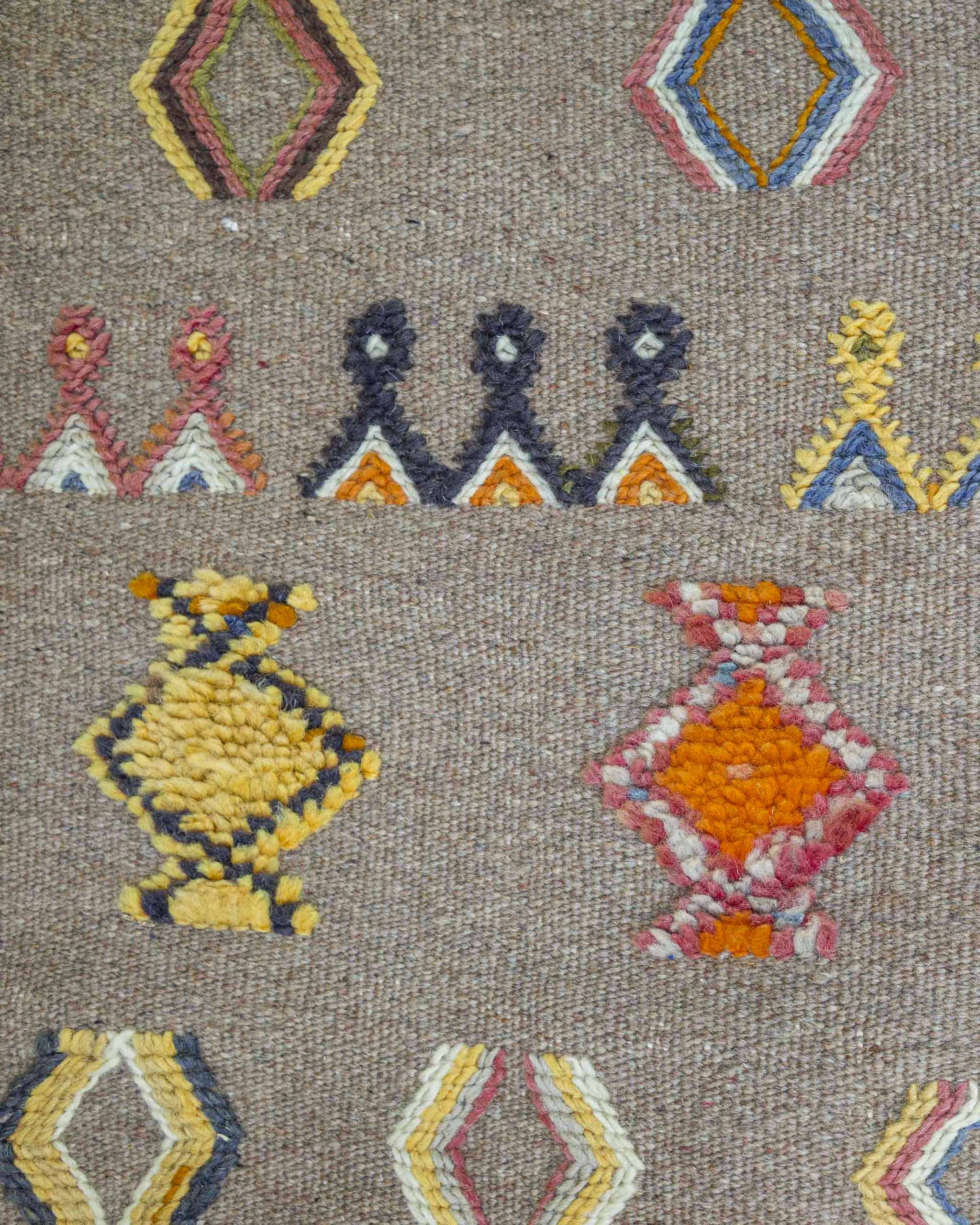 Dettaglio dei simboli berberi ricamati su passatoia in lana color sabbia