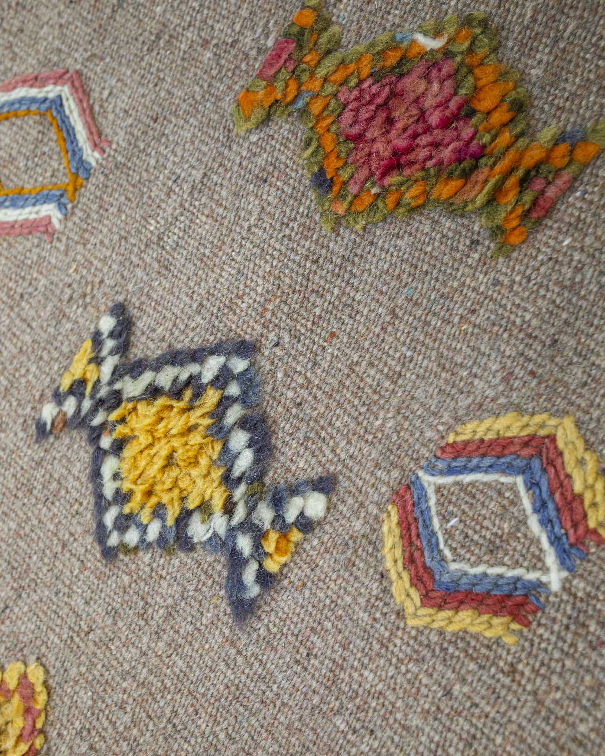 Dettaglio della passatoia kilim in lana beige con decori berberi geometrici colorati