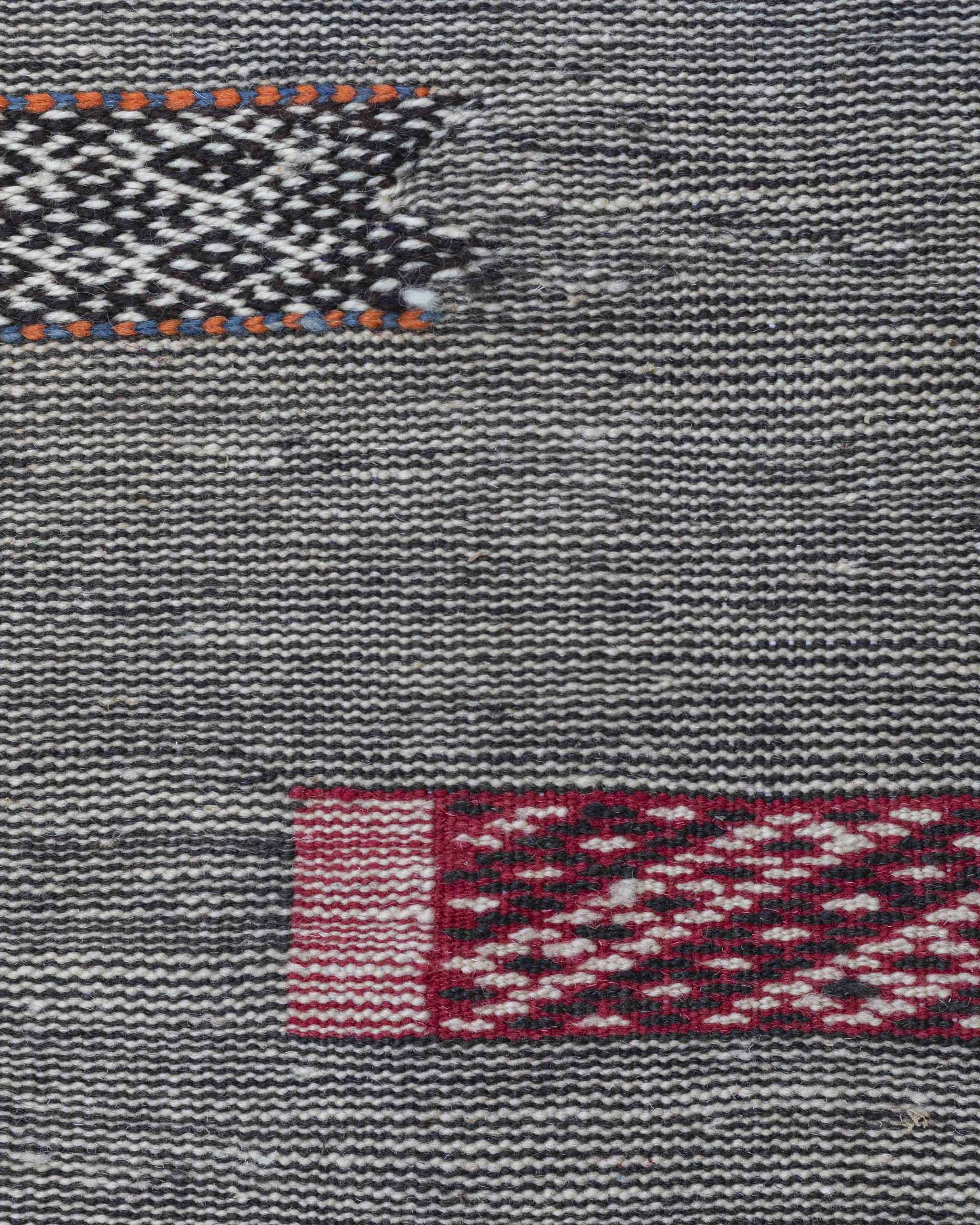 Dettaglio del tappeto a fittissime righe bianche e nere e rettangoli colorati