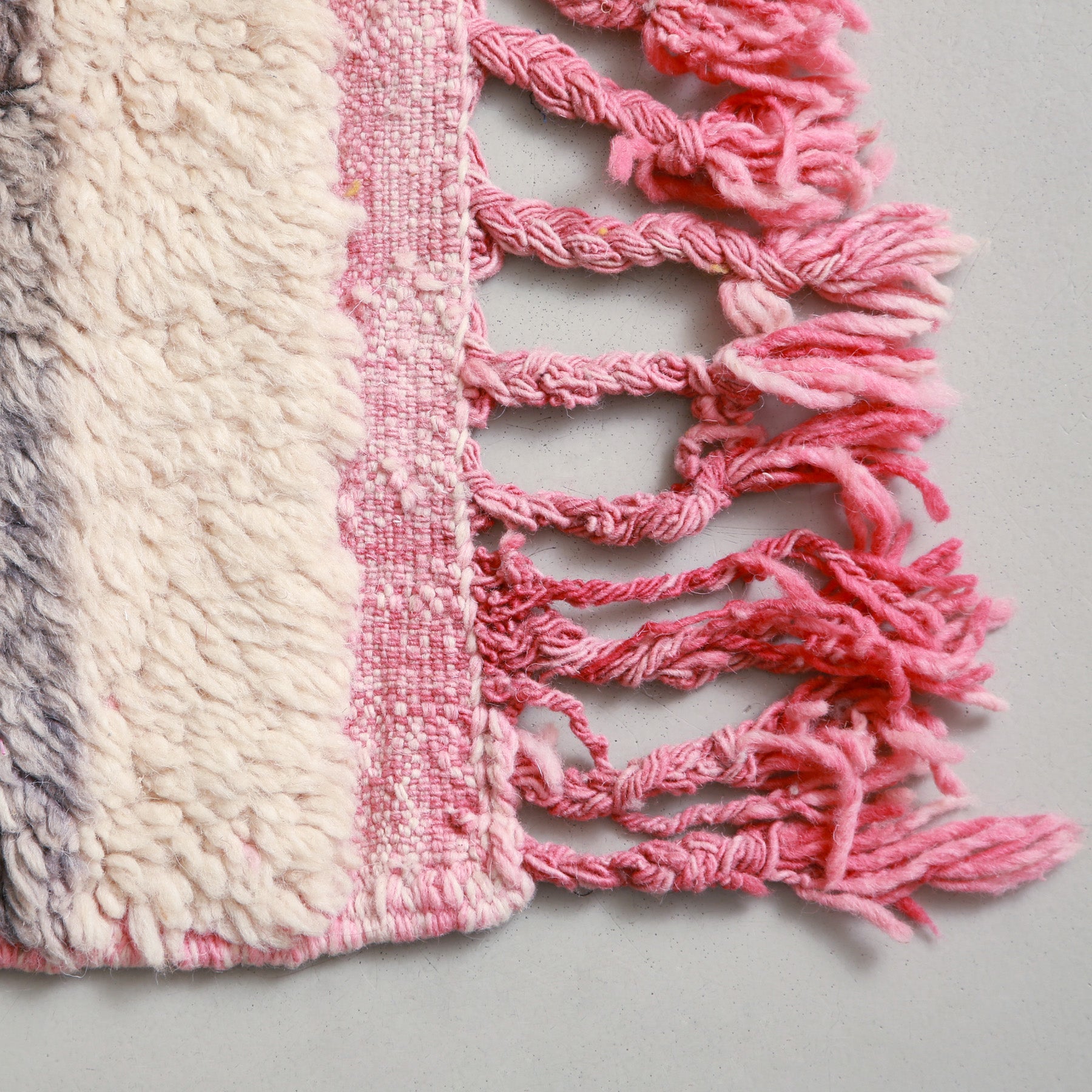 dettaglio della frangia rosa di una passatoia beni ourain in lana bianca