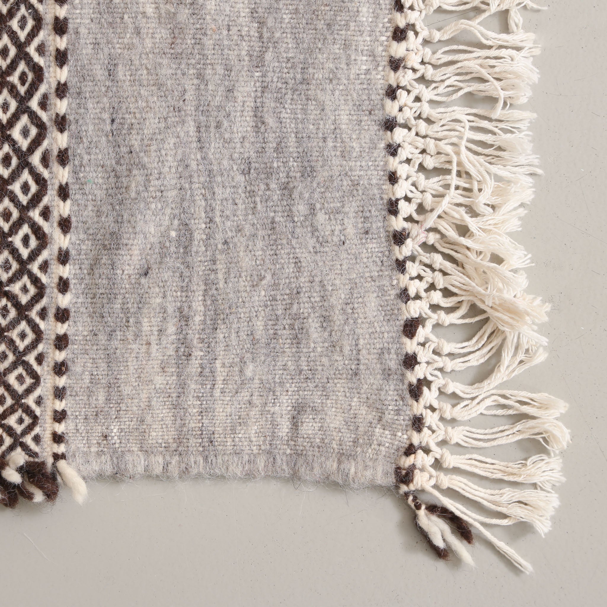 angolo di una passatoia azilal a tessitura piatta in lana colore grigio chiaro