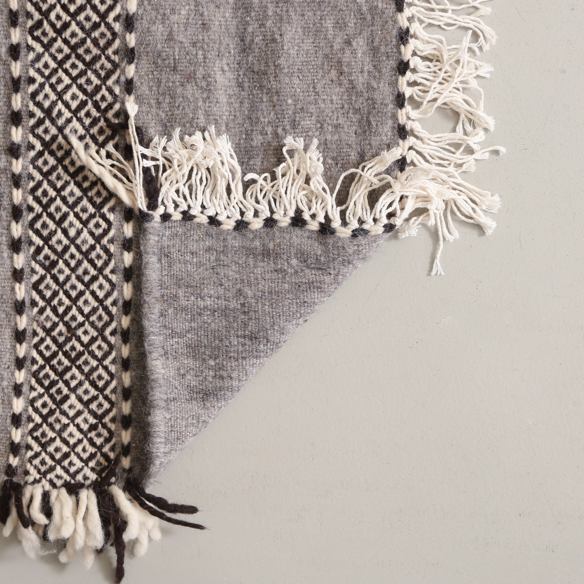 retro di un tappeto artigianale a tessitura piatta in lana grigio scuro