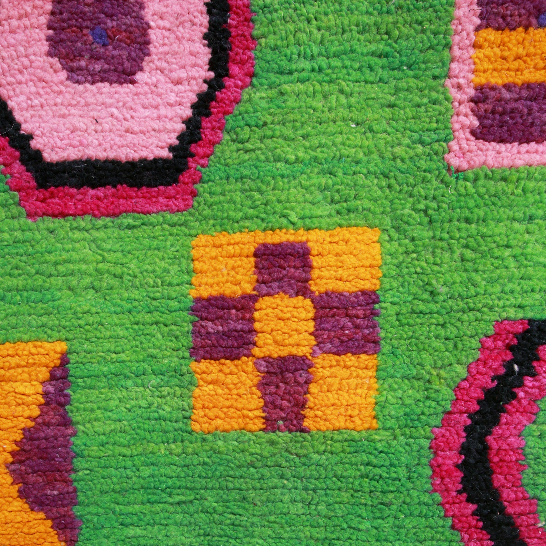 dettaglio di un tappeto boujaad in particola modo di un simbolo con forma geometrico a quadrato giallo con quattro quadrati violi all'interno. 