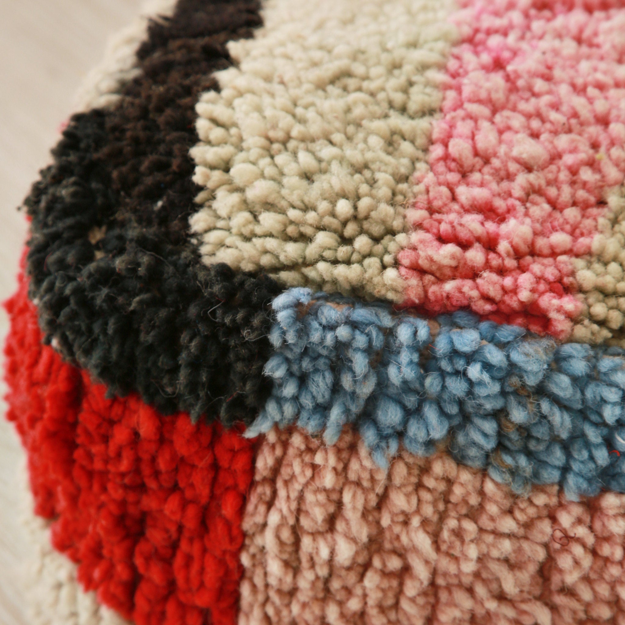 dettaglio dell'angolo di un pouf con rettangoli di lana colorata