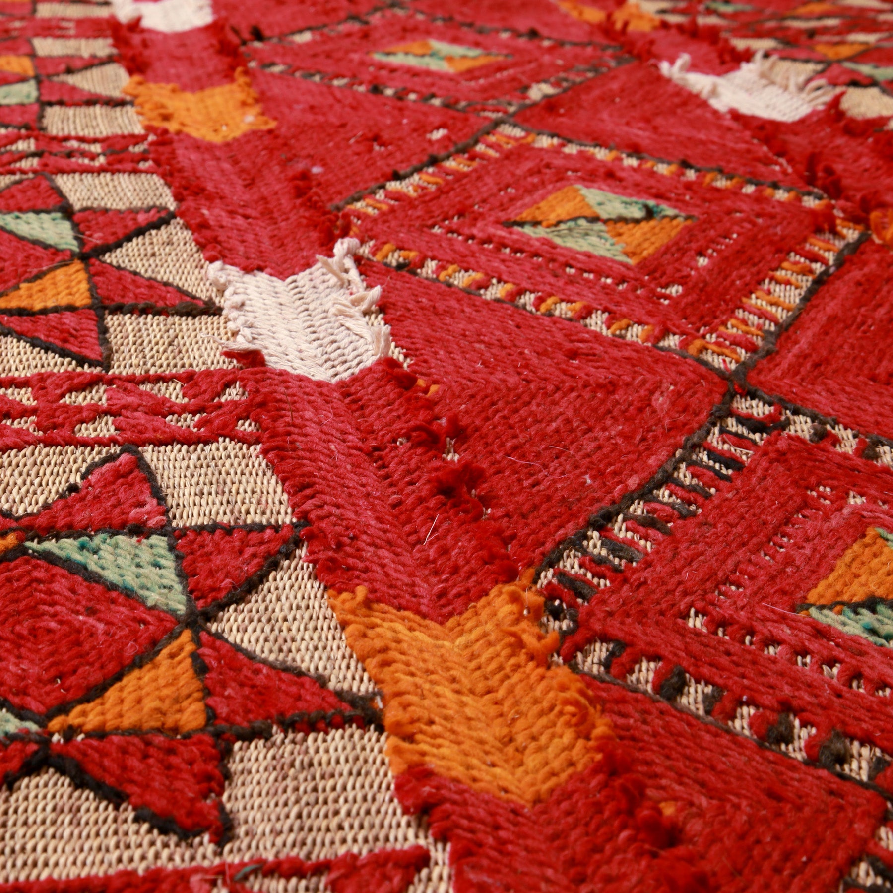 prospettica del fitto ricamo in lana su una stuoia vintage in paglia di palma