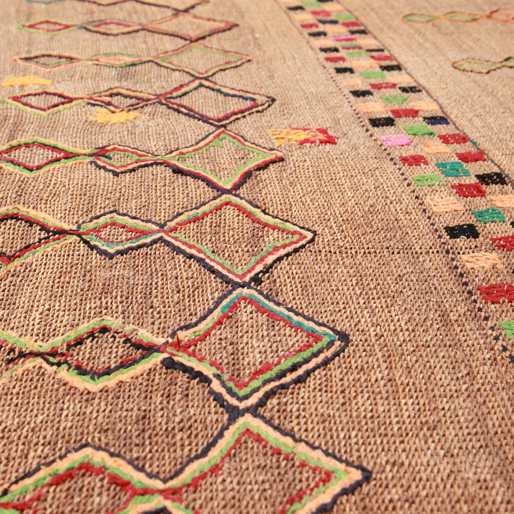 dettaglio di una stuoia hassira vintage in paglia di palma e ricami in lana