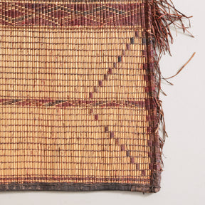 angolo di di una stuoia tuareg realizzata a mano tessendo cuoio su legno di palma con frecce e bande