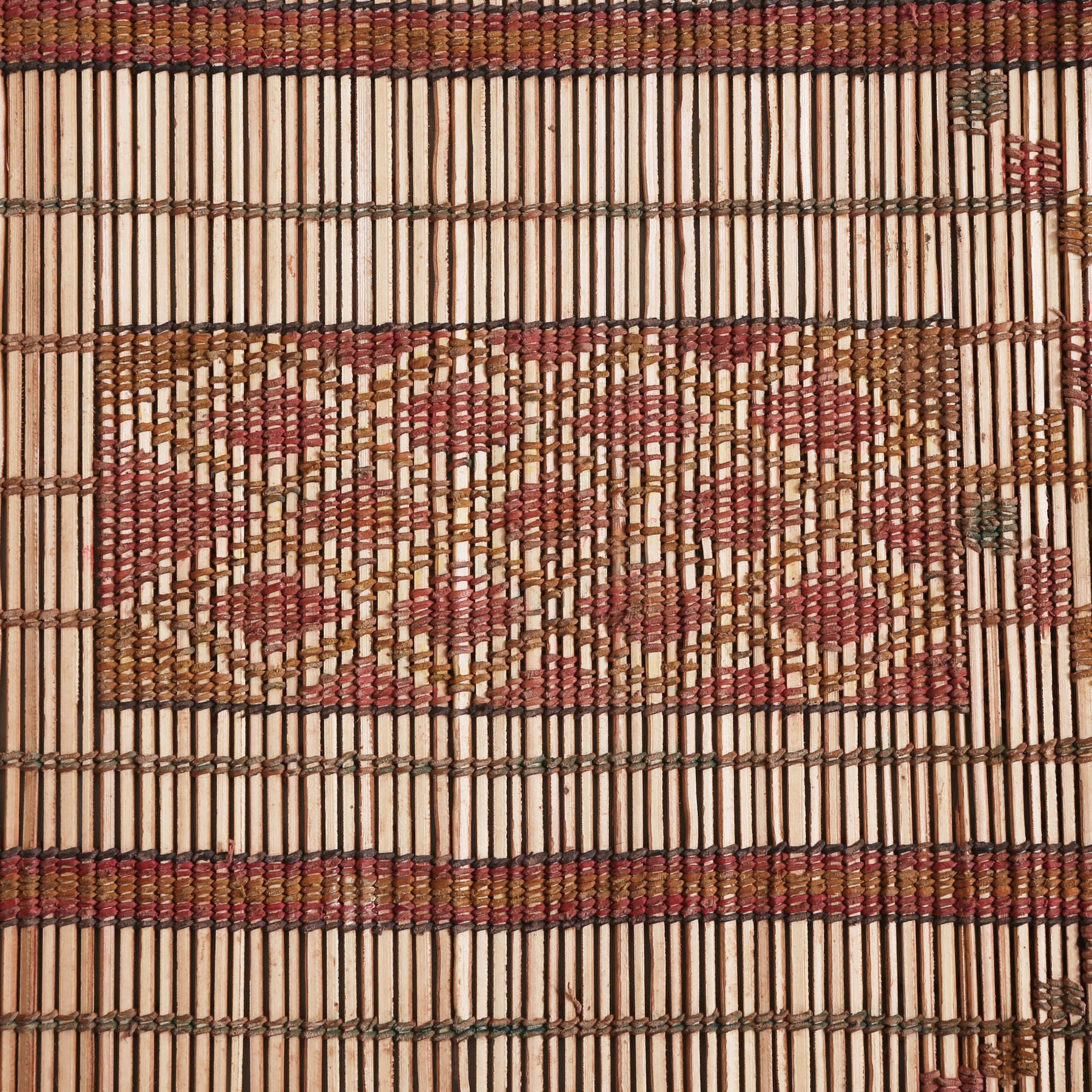dettaglio di un simbolo lavorato con fili di cuoio ocra e rosso