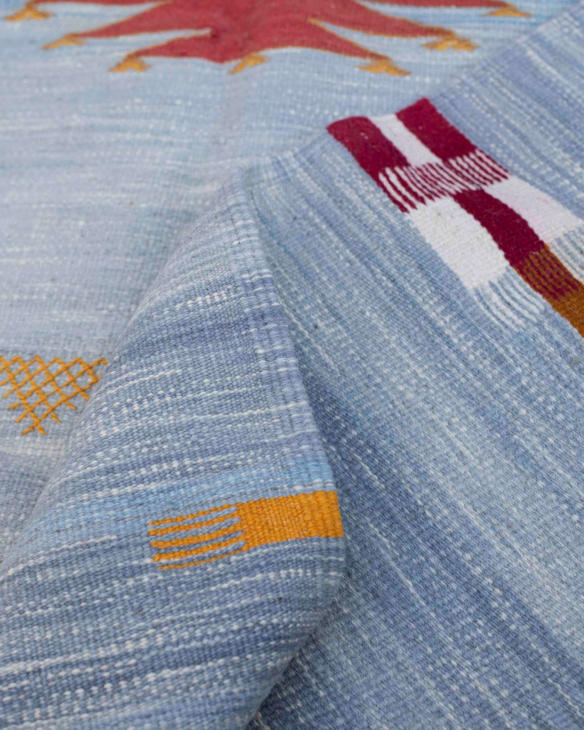 Dettaglio tappeto kilim Akhnif: tessitura piatta in lana azzurro polvere con abrash, intreccio compatto e piccoli accenti colorati