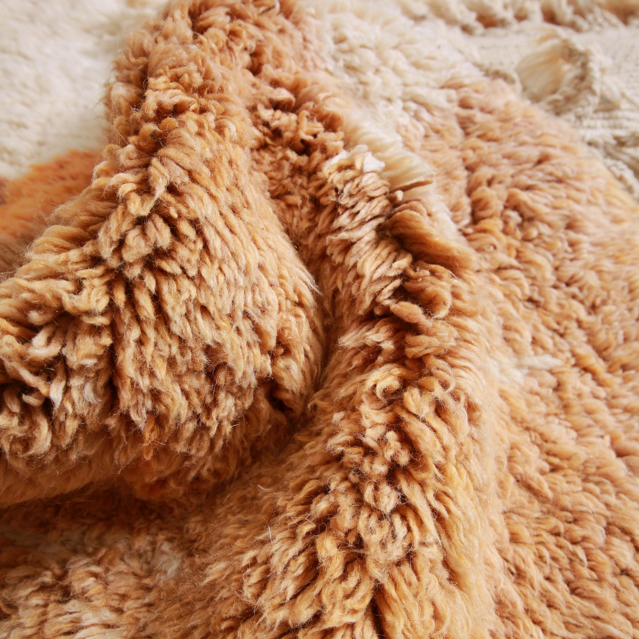 Tappeto Beni Ourain colorato in lana marocchina con texture a pelo lungo e dettaglio delle sfumature avorio e arancione terracotta