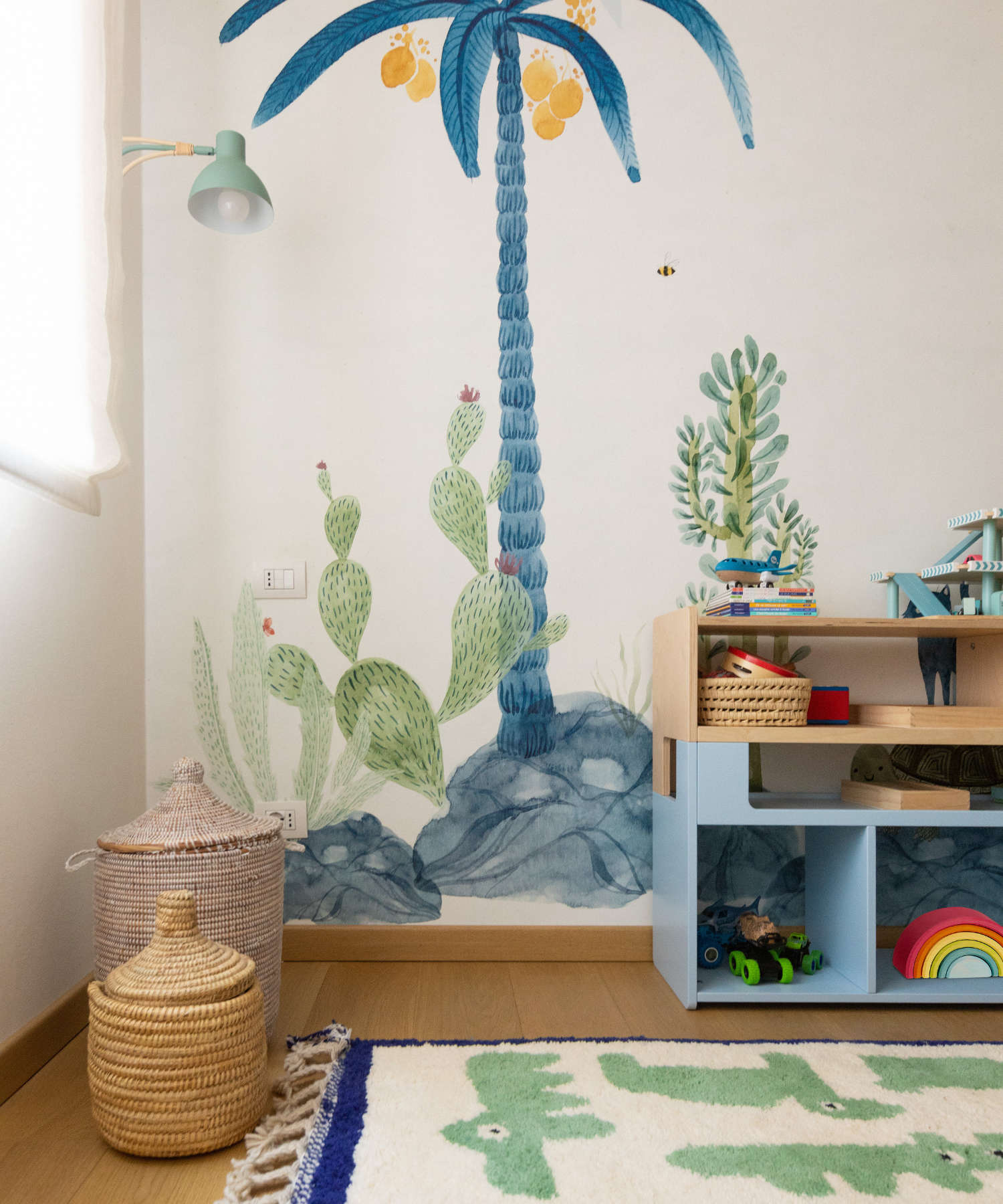 Tappeto Animauì verde in cameretta montessoriana, arredo sostenibile con lana marocchina, ambientazione con murales tropicali e accessori naturali