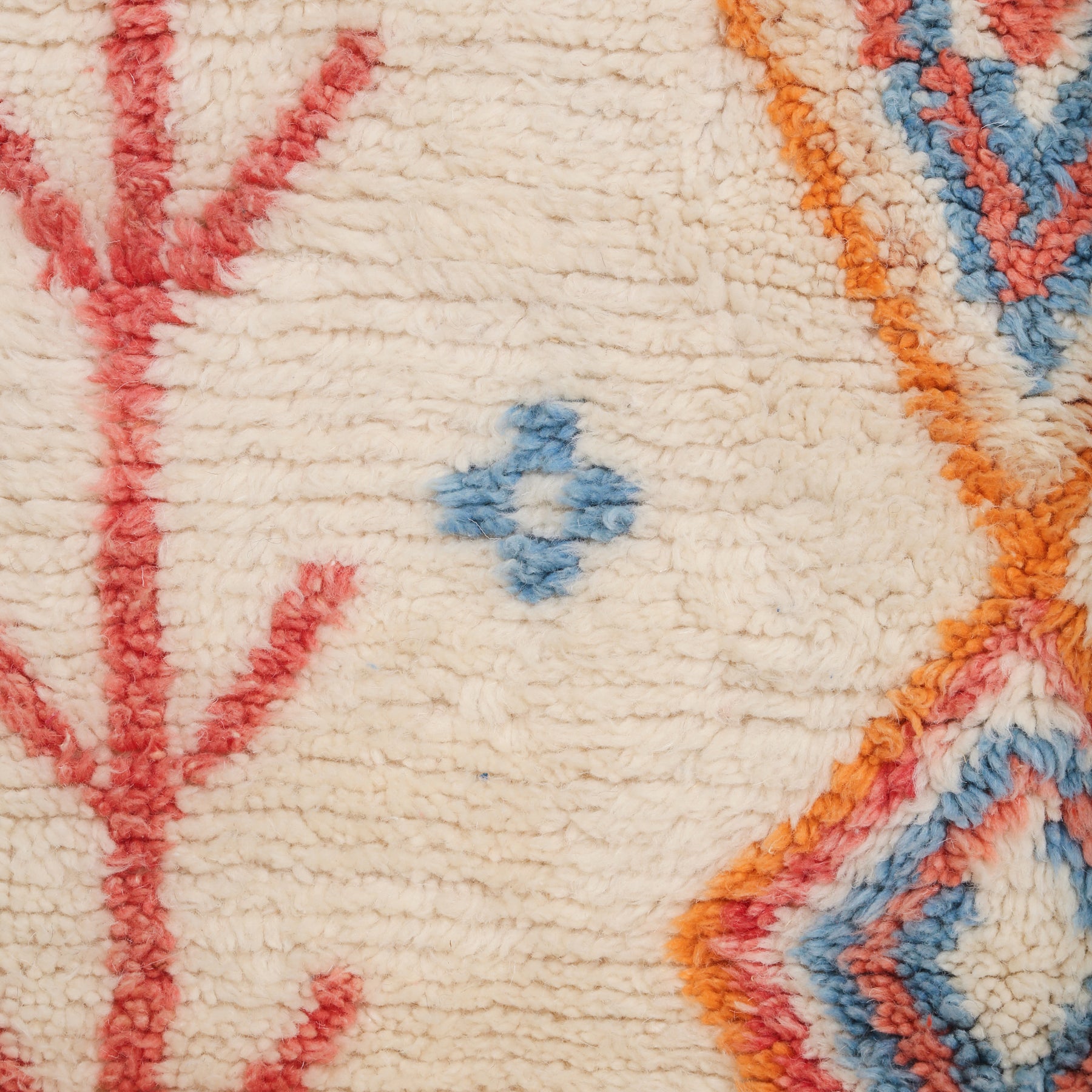 dettaglio della lana chiara e brillante di un tappeto, nonche di alcuni simboli visibili sul tappeto
