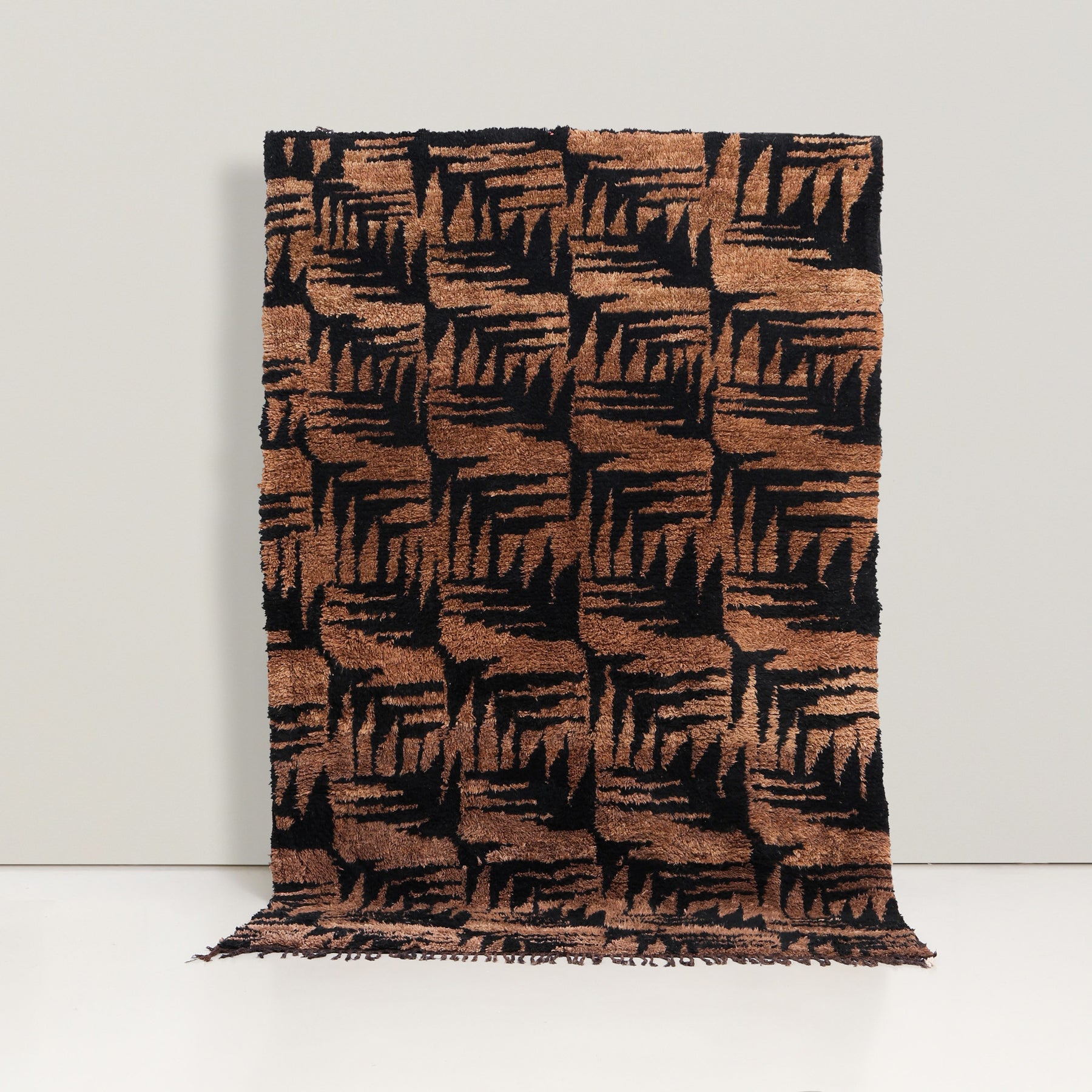 tappeto azial con la marrone colorata con la noce e disegni neri che ricordano delle foglie di pini o delle piume