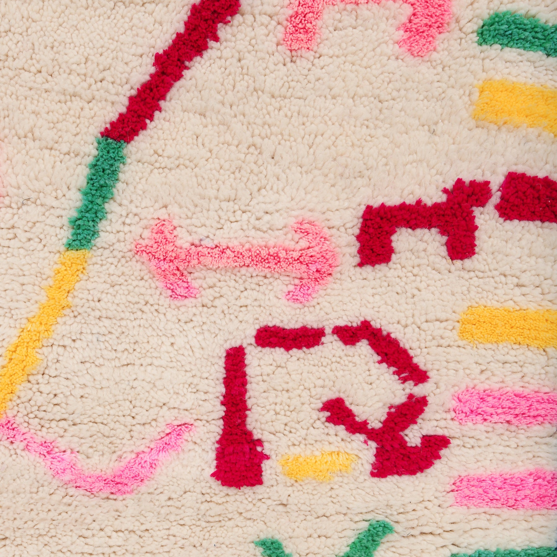 dettaglio dei simboli colorati rosso,rosa giallo e verde di un tappeto della regione di azilal