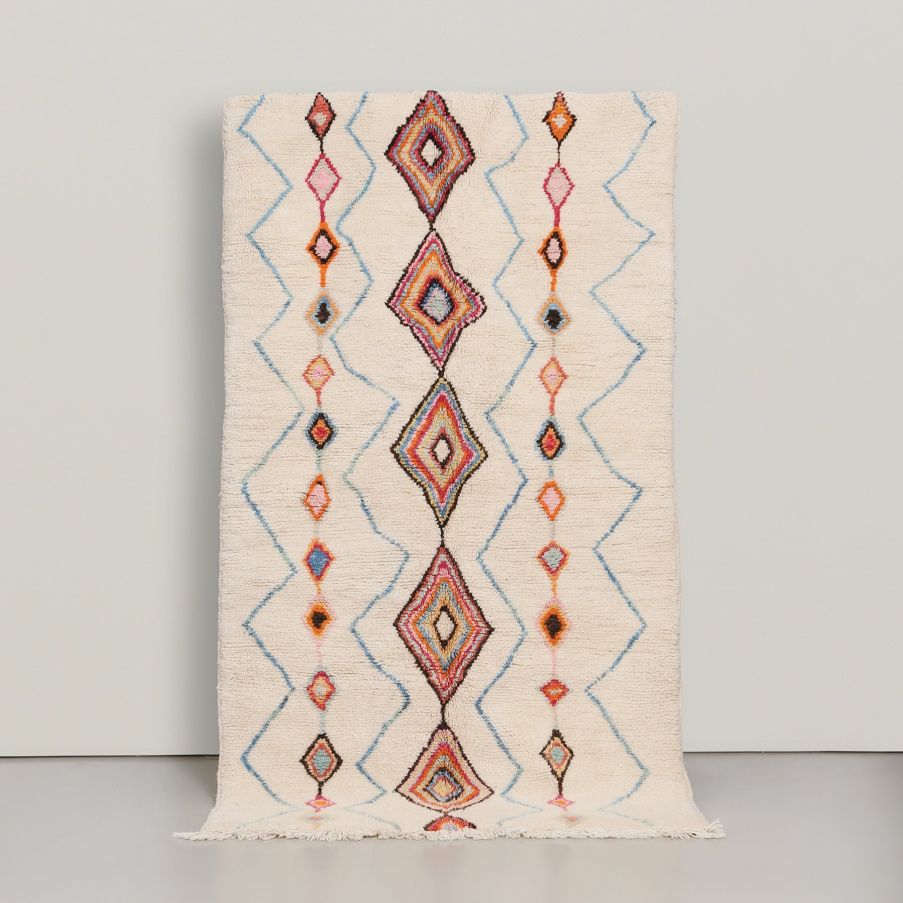 tappeto azilal in lana colo avorio con simboli colorati , come una riga centrale di rombi e quattro  righe spezzate azzurre