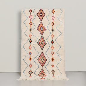 tappeto azilal in lana colo avorio con simboli colorati , come una riga centrale di rombi e quattro  righe spezzate azzurre