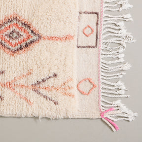 dettaglio dell'angolo e della frangia ricamata di un tappeto realizzato a mano in lana