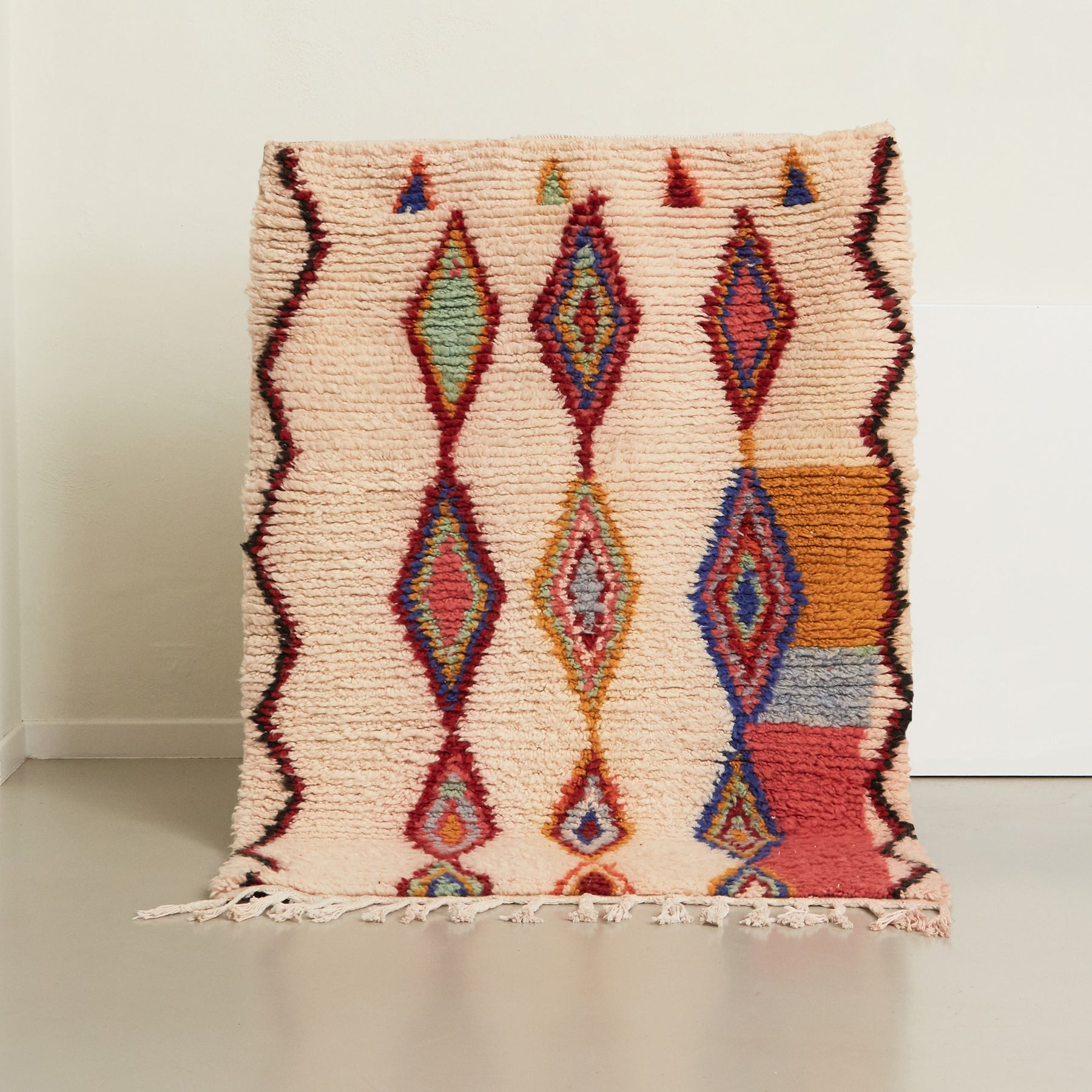 tappeto azilal realizzato a mano con con tre file rombi ricamati con differenti colori e un bordo con una riga spezzata rossa e nera