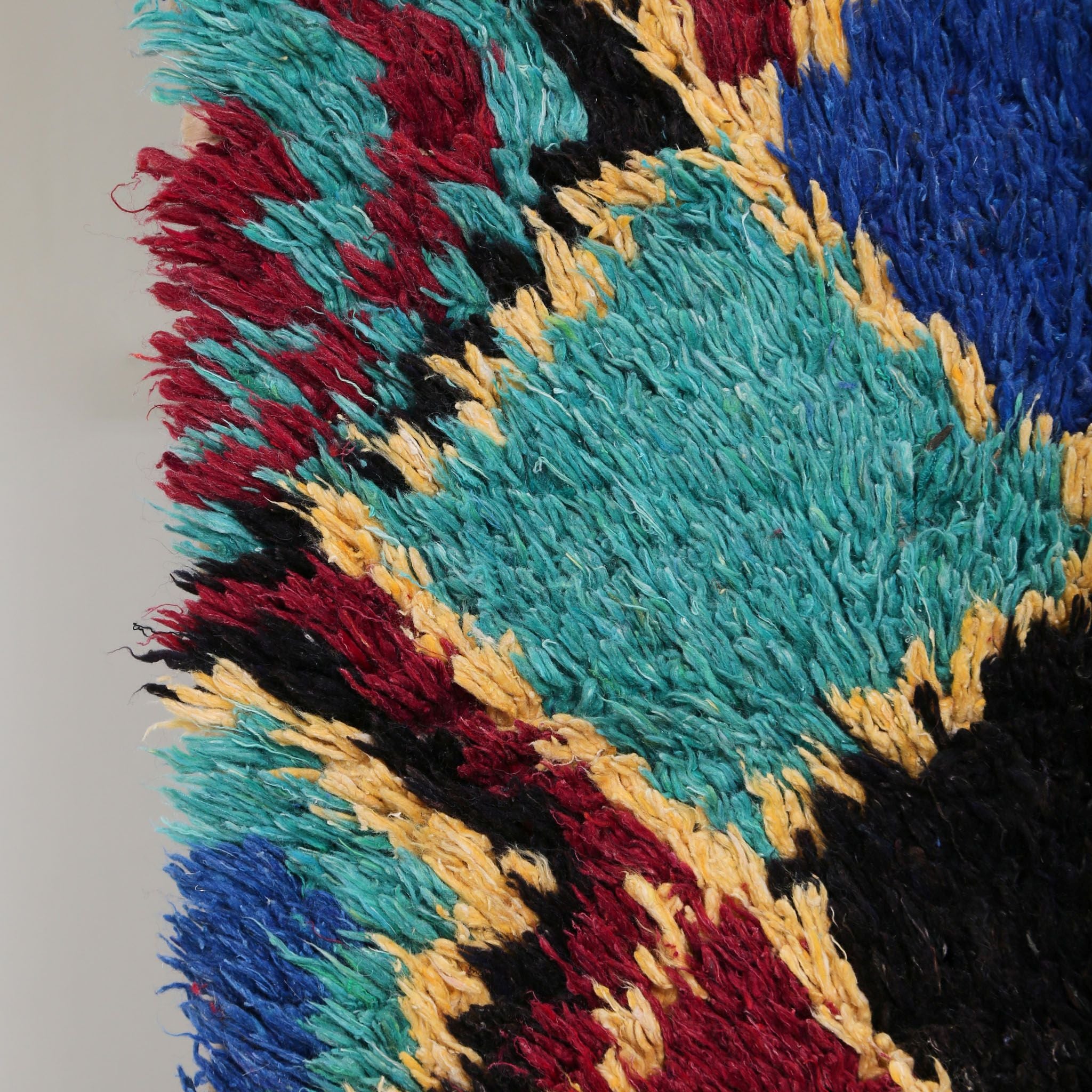 dettaglio ravvicinato della texture in lana del tappeto Azilal vintage, dettaglio della lavorazione artigianale e dei colori naturali con rombo turchese e bordo giallo nero e bordeaux 