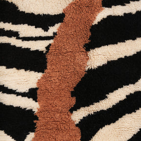dettaglio della lana color cammello, nera e bianca di un tappeto