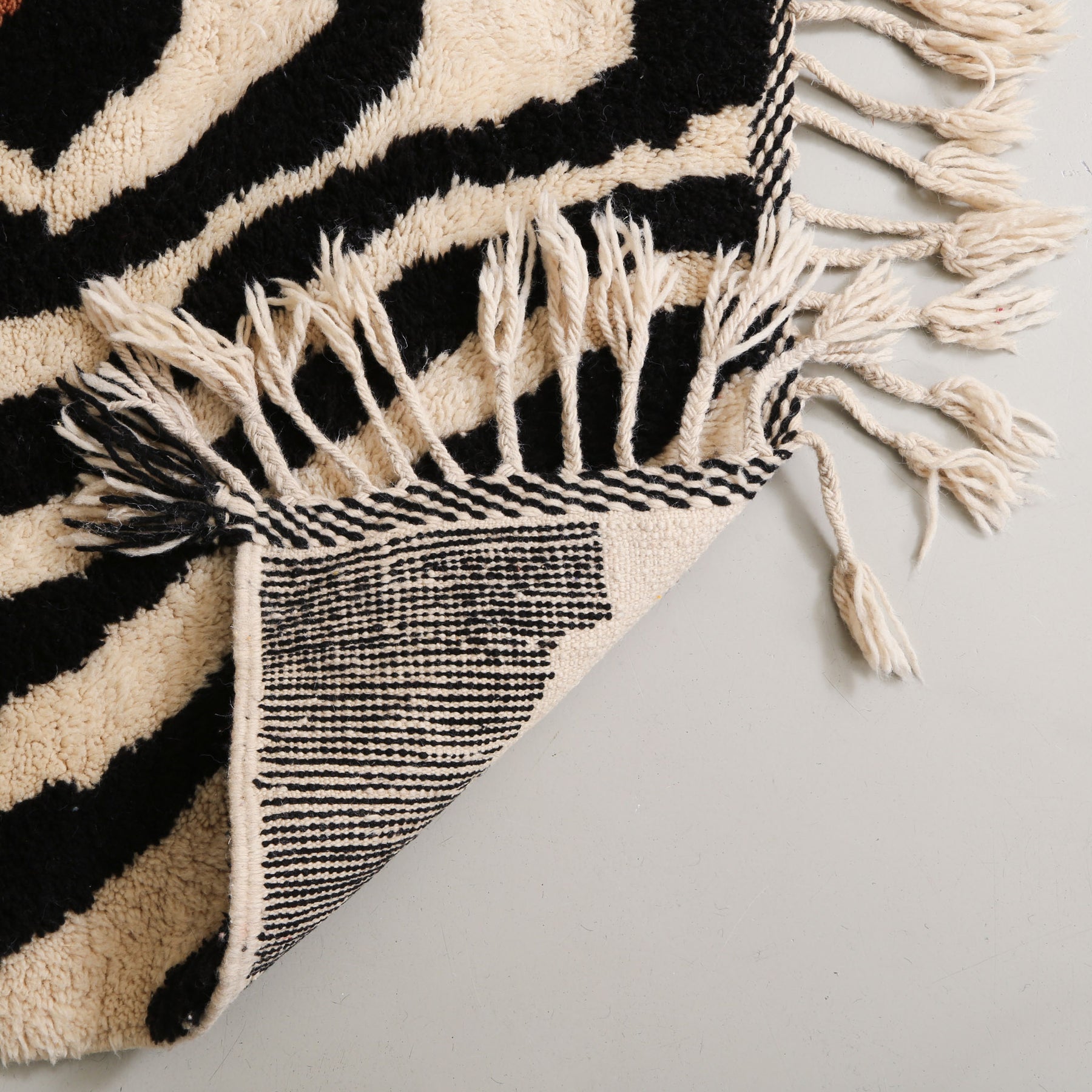 retro di un tappeto in lana zebrato per ammirare la precisione dei nodi