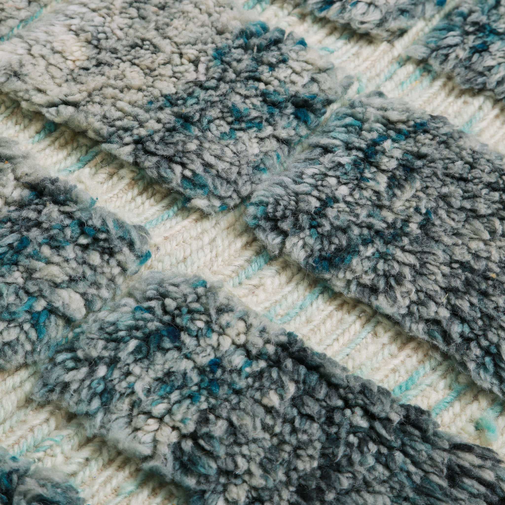 Dettaglio texture tappeto Beni Ourain berbero in lana naturale con motivo geometrico nei toni acquamarina e grigio su base crema, ideale per soggiorno moderno e stile scandinavo.