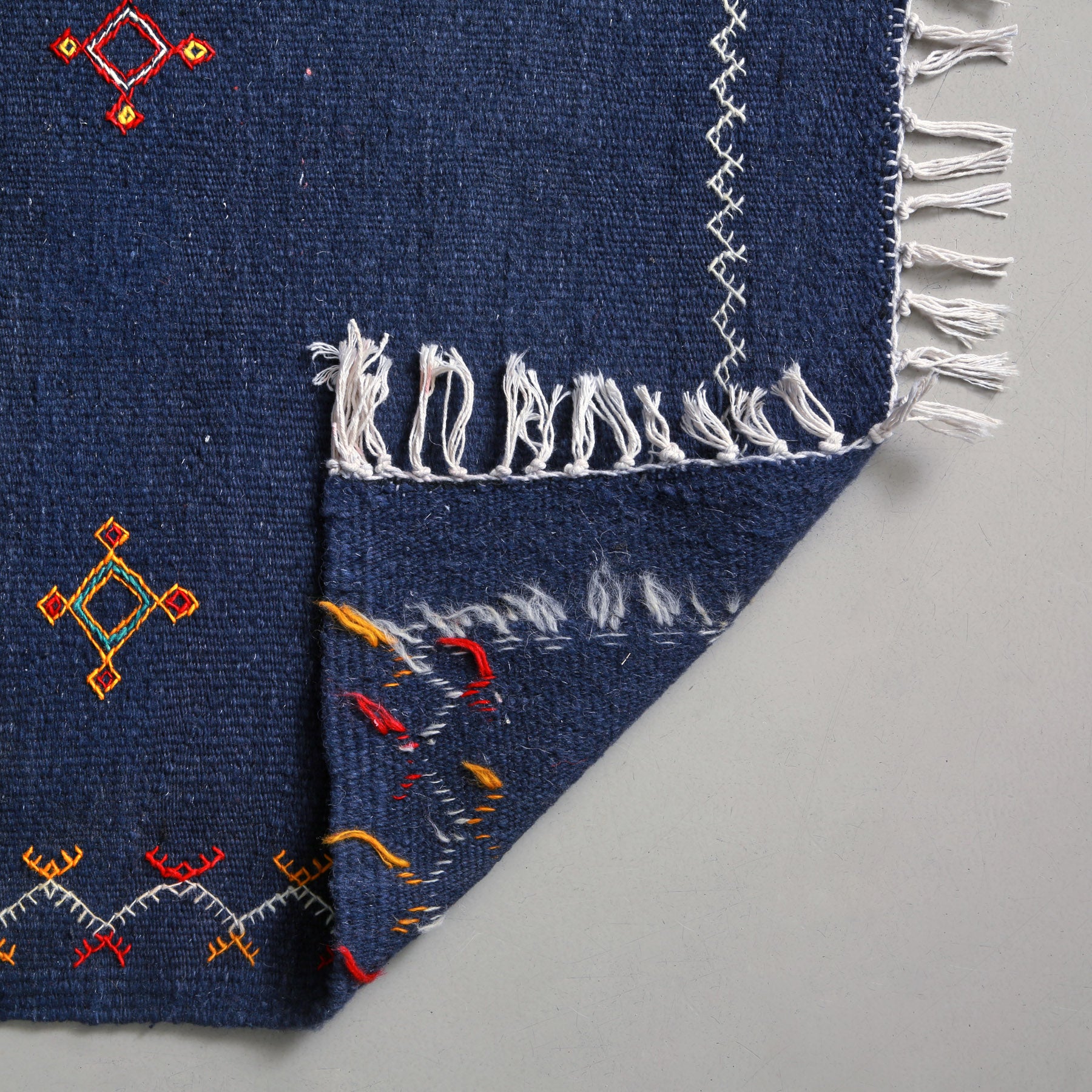 dettaglio del retro di un tappeto artigianale marocchino a tessitura piatta blu