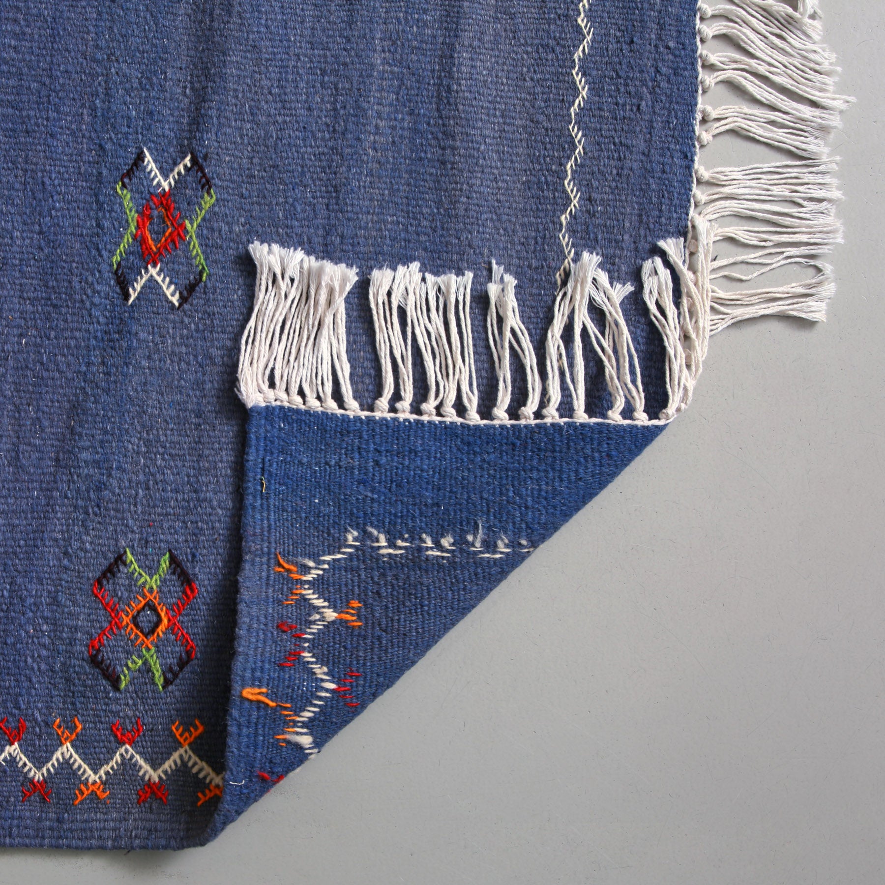 dettaglio del retro di un tappeto marocchino berbero akhnif in tessuto a mano con lana color blu 