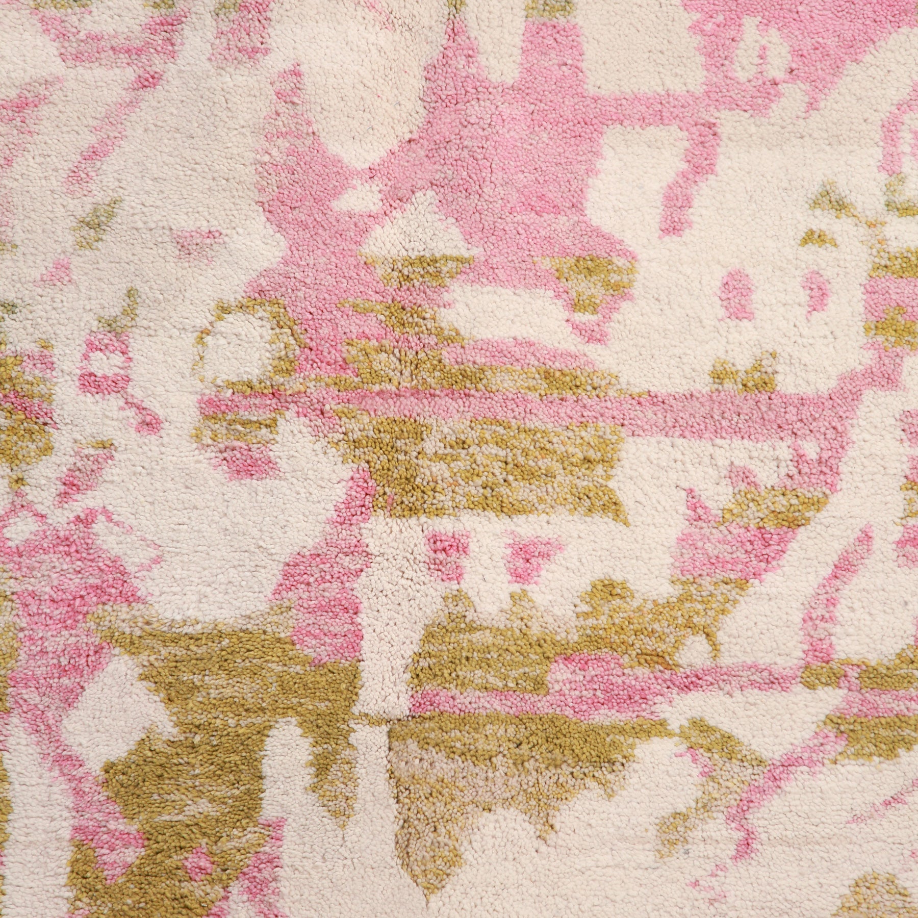 dettaglio dei disegni astratti rosa e verde pastello di un tappeto artigianale marocchino beni ourain
