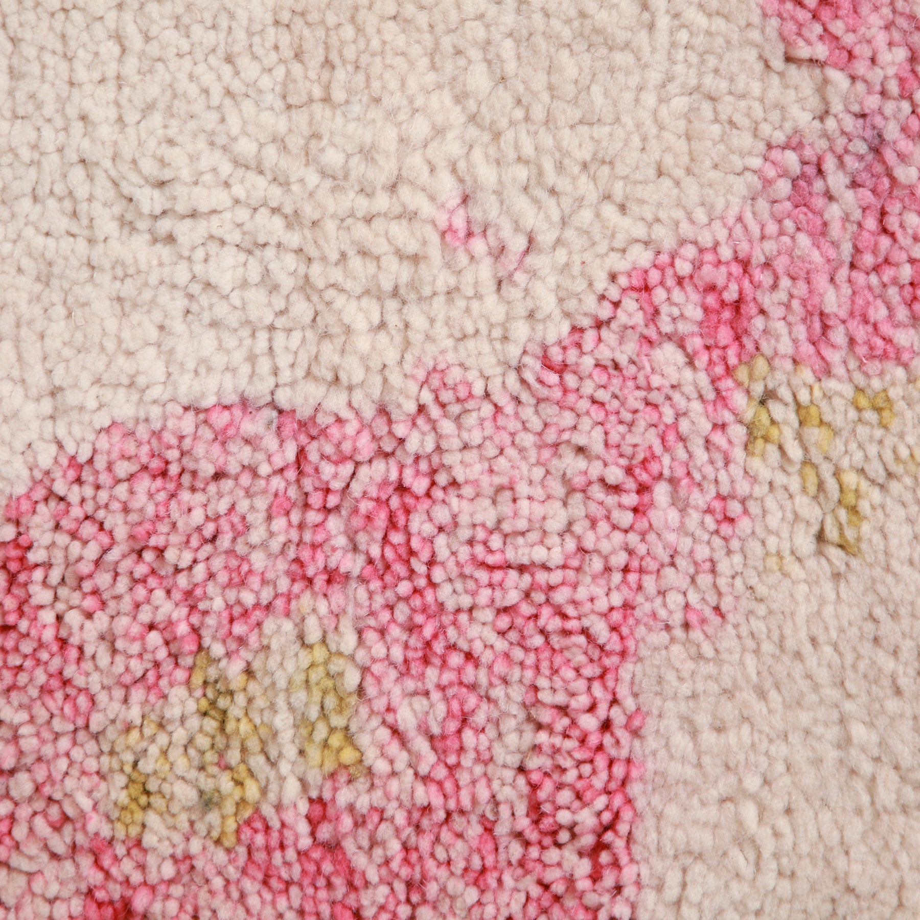 dettaglio ravvicinato del pelo di lana bianca e coor rosa sfumato di un tappeto artigianale marocchino beni ourain