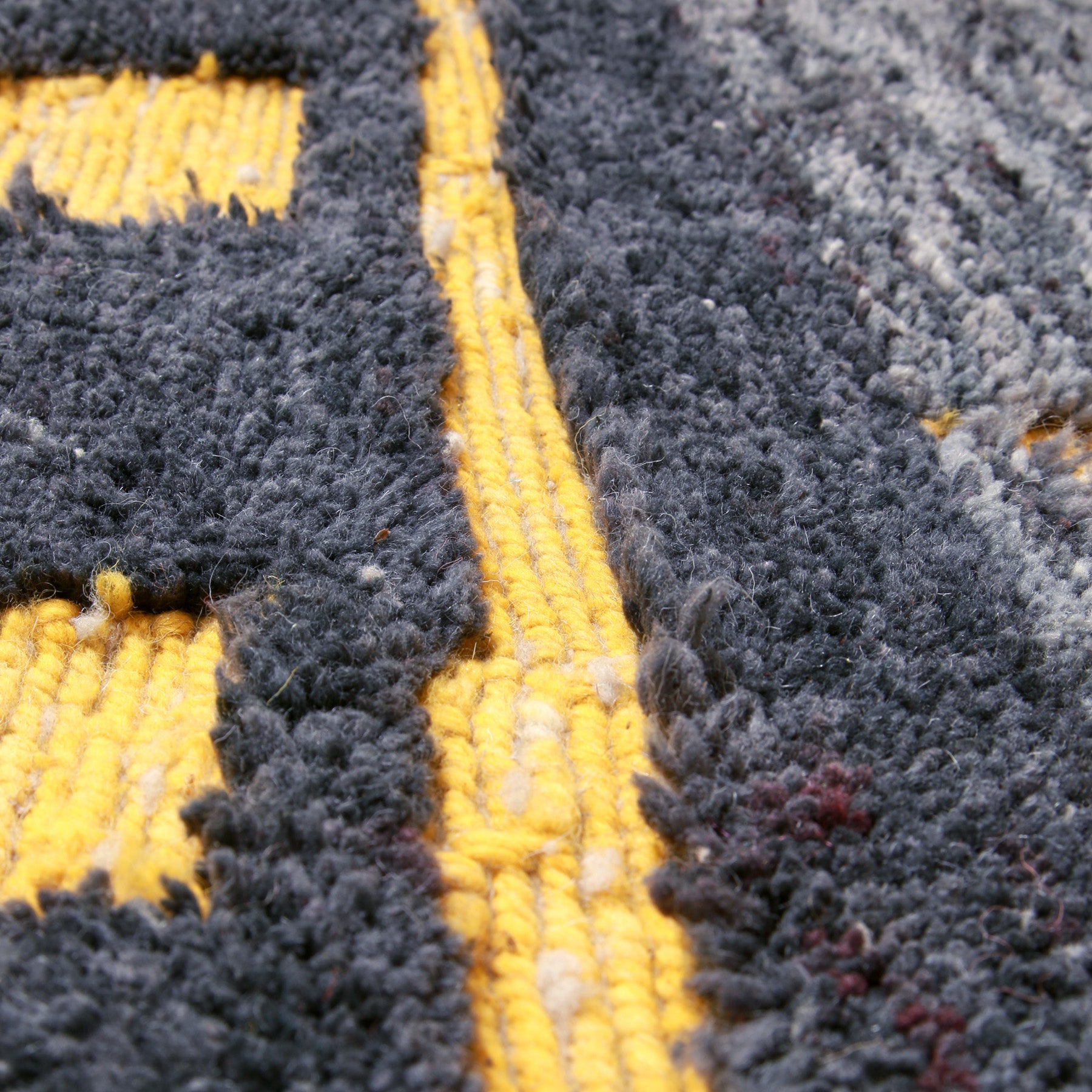 dettaglio di una linea in lana intrecciata color giallo di un tappeto marocchino beni ourain realizzato a mano
