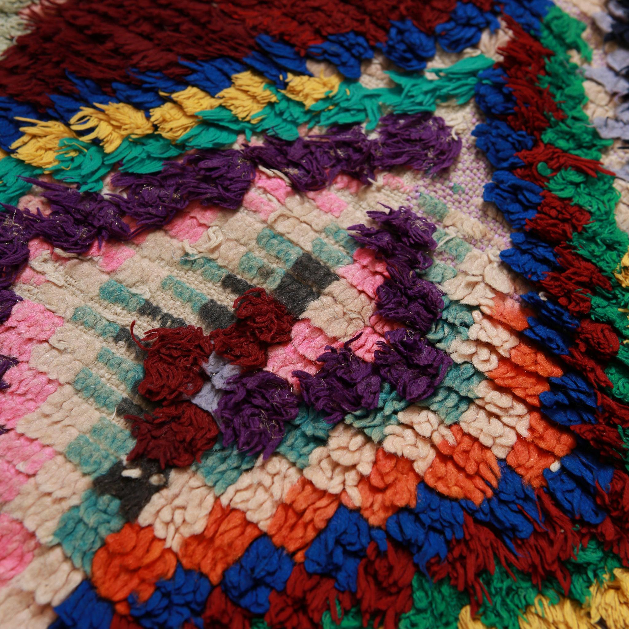 Dettaglio annodatura tappeto boucherouite marocchino con fibre colorate intrecciate e motivi tradizionali amazigh
